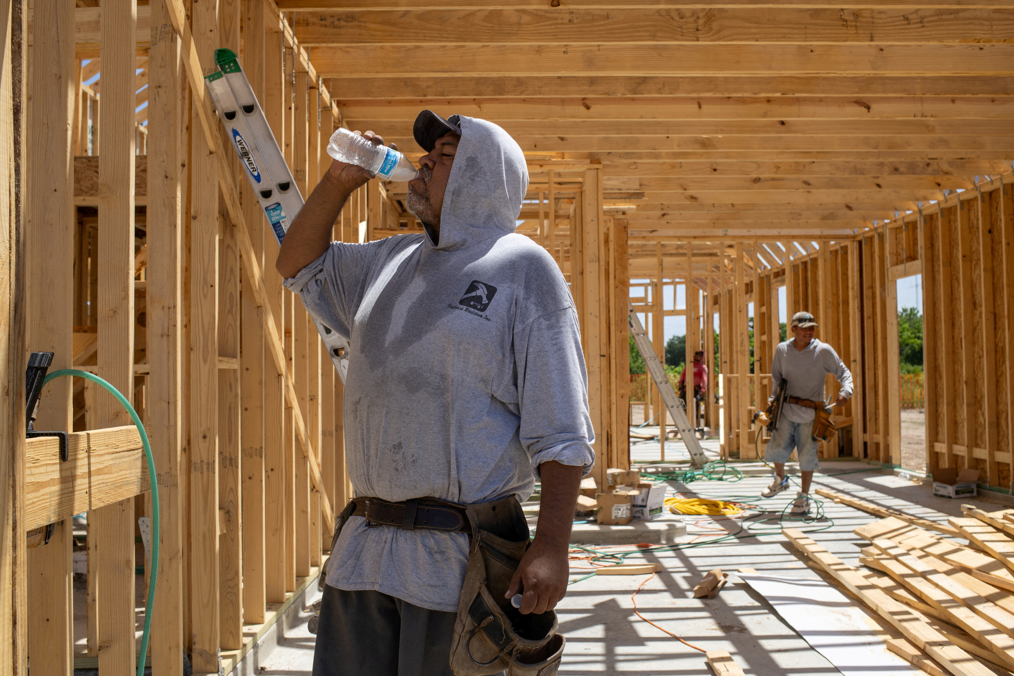 Builder takes water break during hot weather in Manvel, Texas