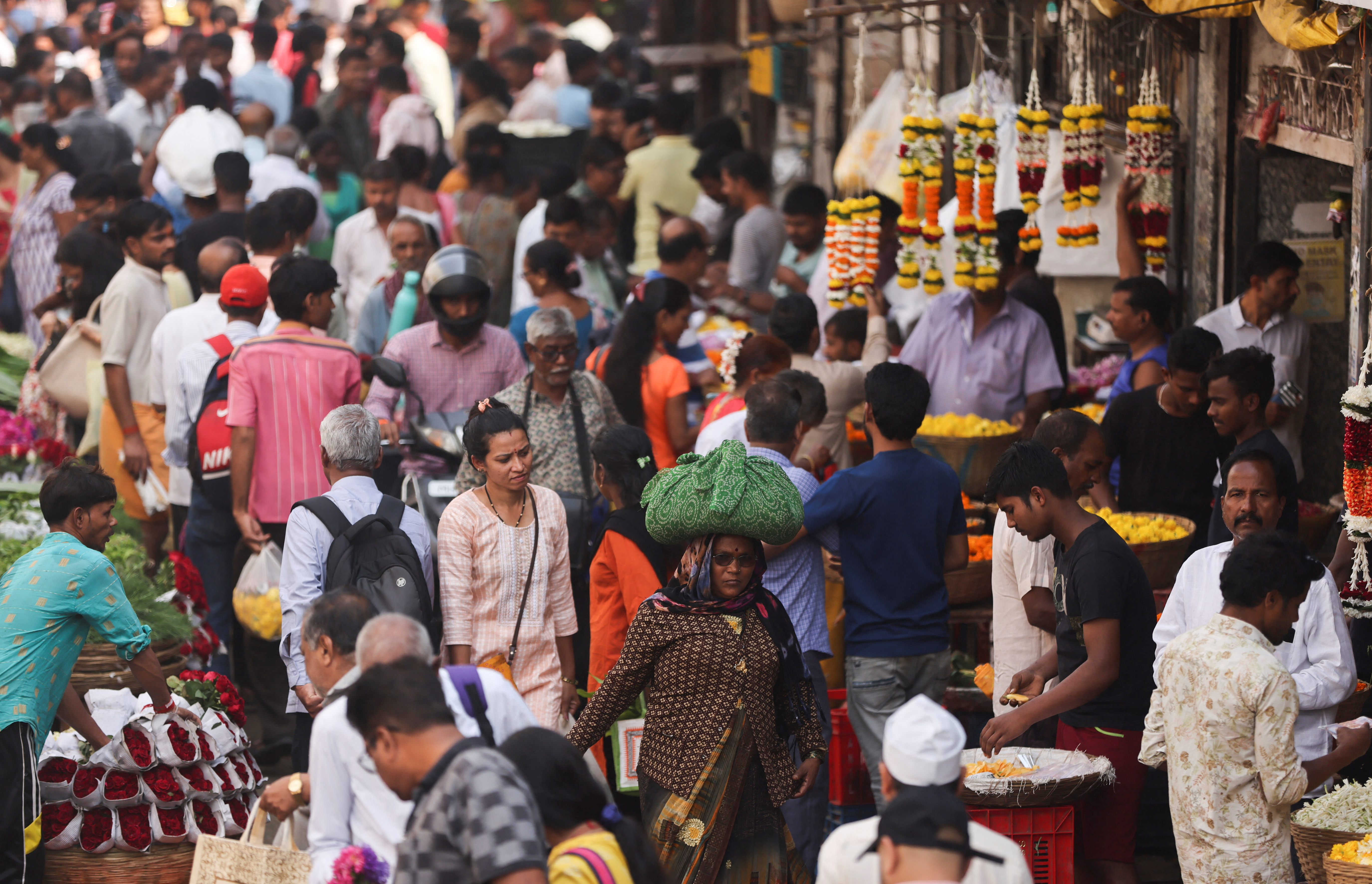 People walk through a crowded market in Mumbai