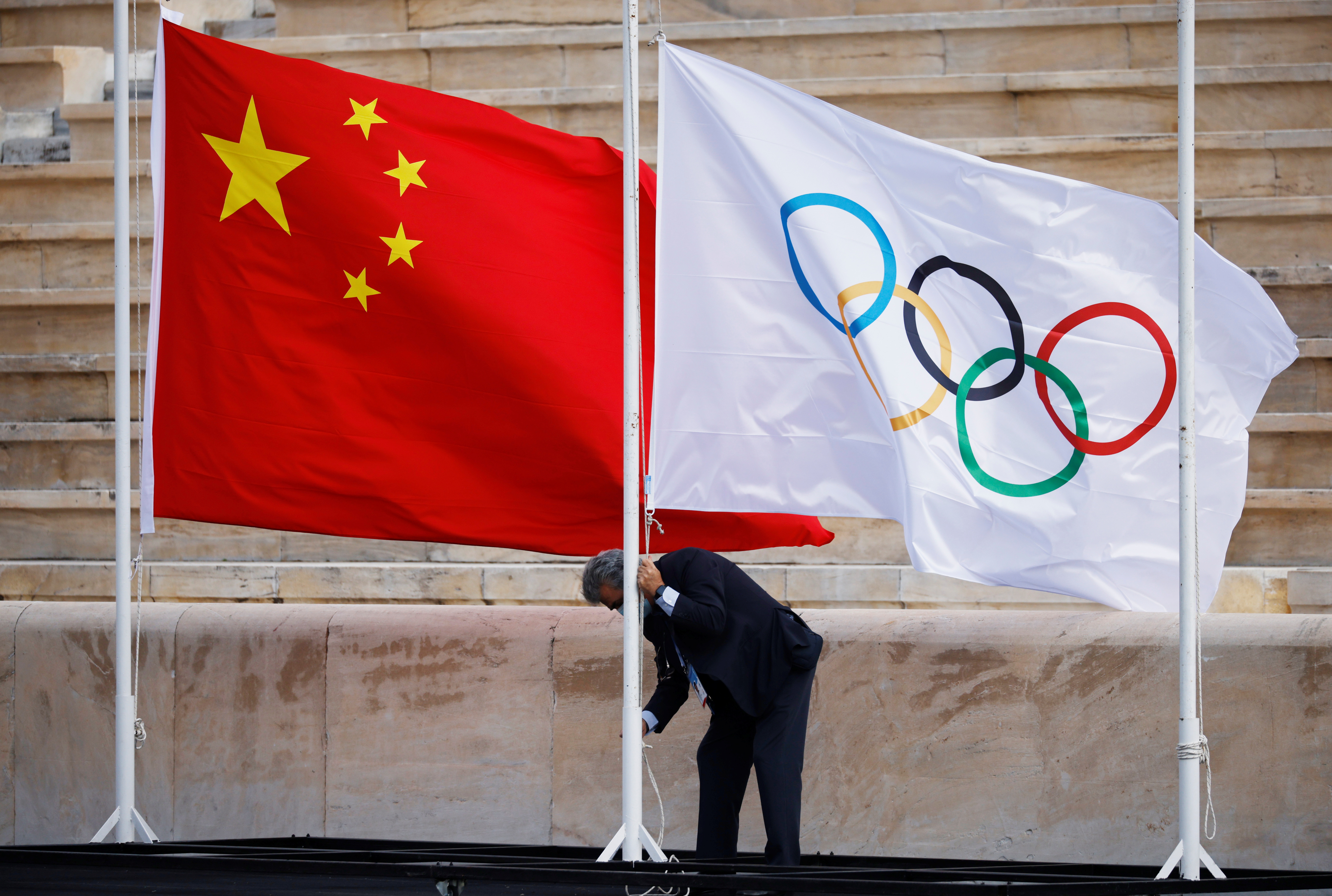Winter Olympics - Flame handover ceremony in Athens for the Beijing 2022 Winter Olympics - Panathenaic Stadium, Athens, Greece - October 19, 2021 The flags of China and the Olympics are seen being raised before the ceremony REUTERS/Alkis Konstantinidis/File Photo