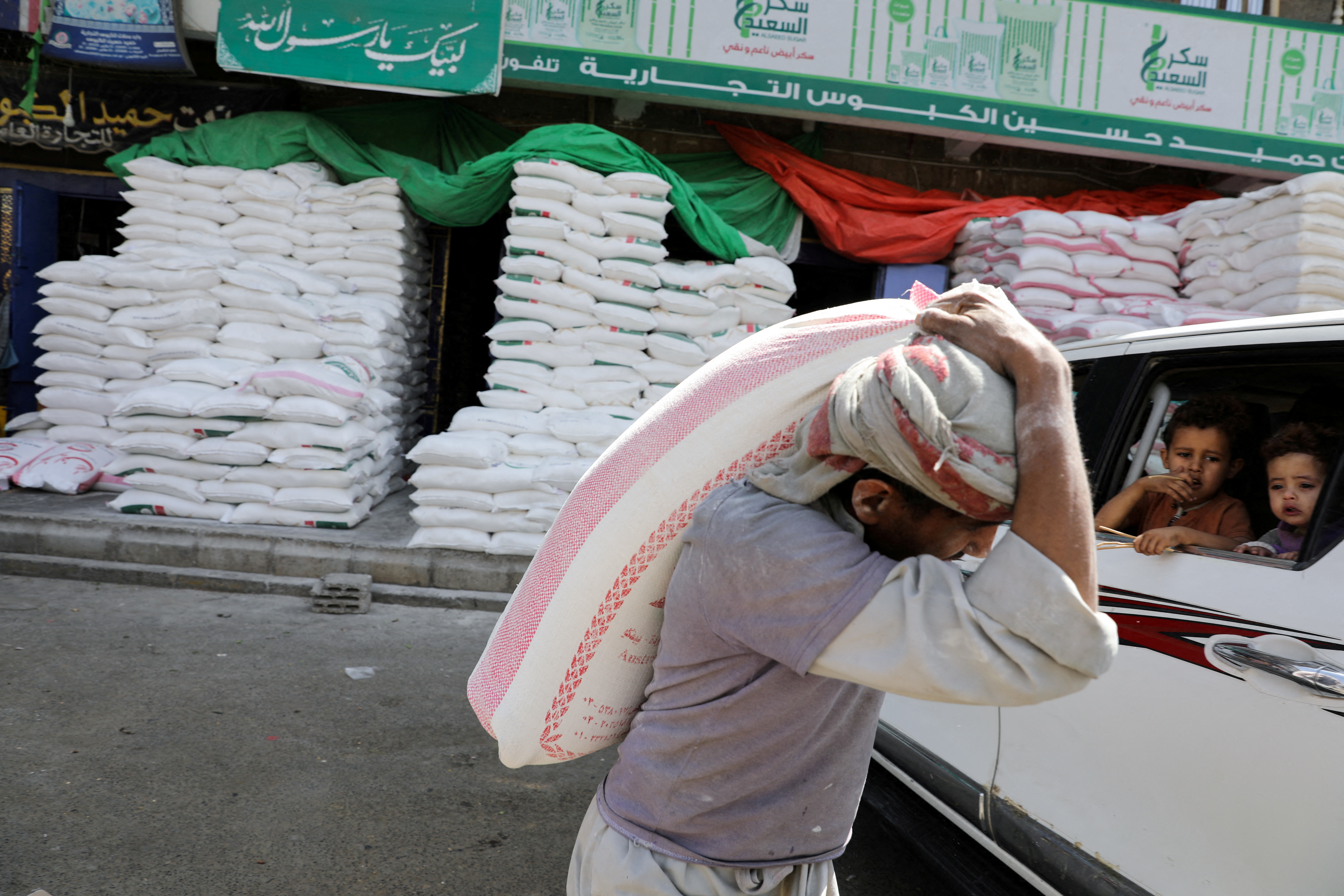 Worker carries a sack of wheat flour in Sanaa