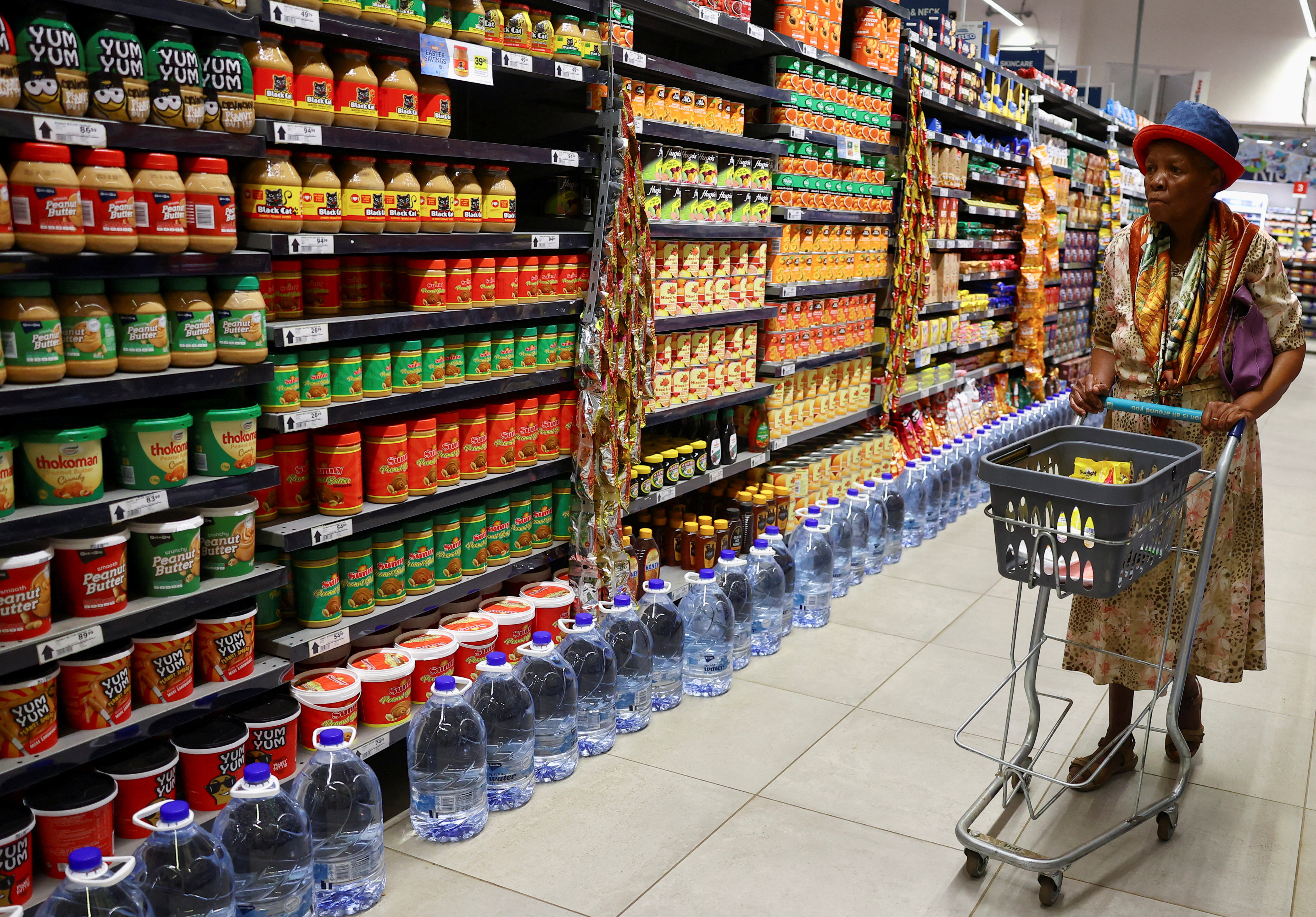A woman uses a trolley as she shops at a Pick n Pay store, in Soweto
