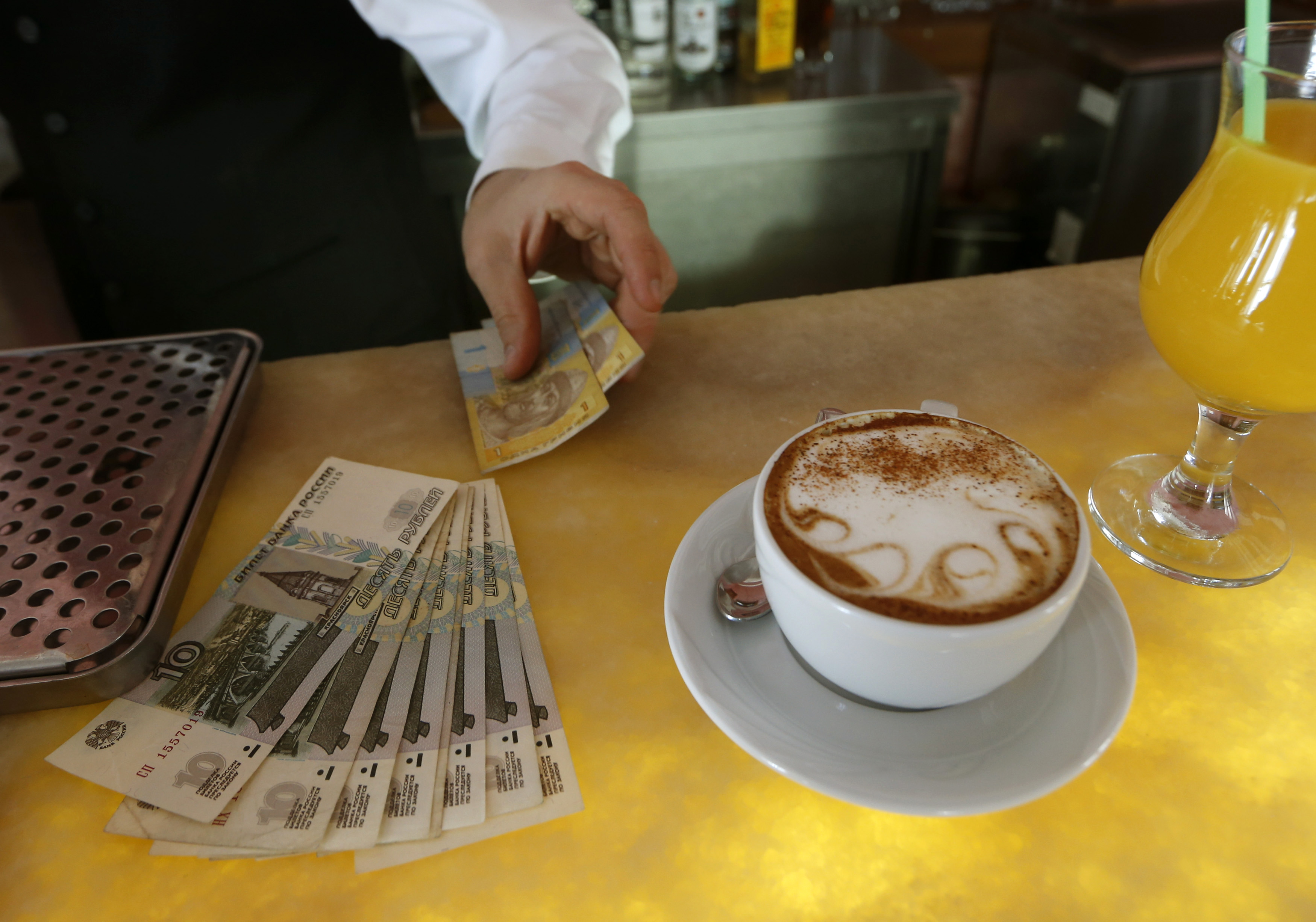 Waiter counts Russian roubles and prepares Ukranian hryvnia for a change in a restaurant in Sevastopol