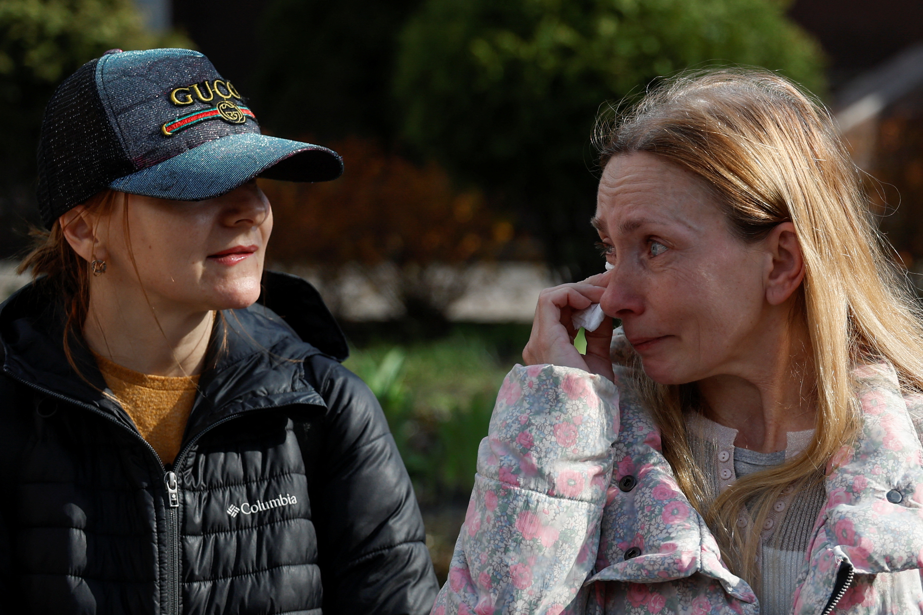 Iryna and Anastasia react as they wait for arrival of their children after their returning via the Ukraine-Belarus border, in Kyiv