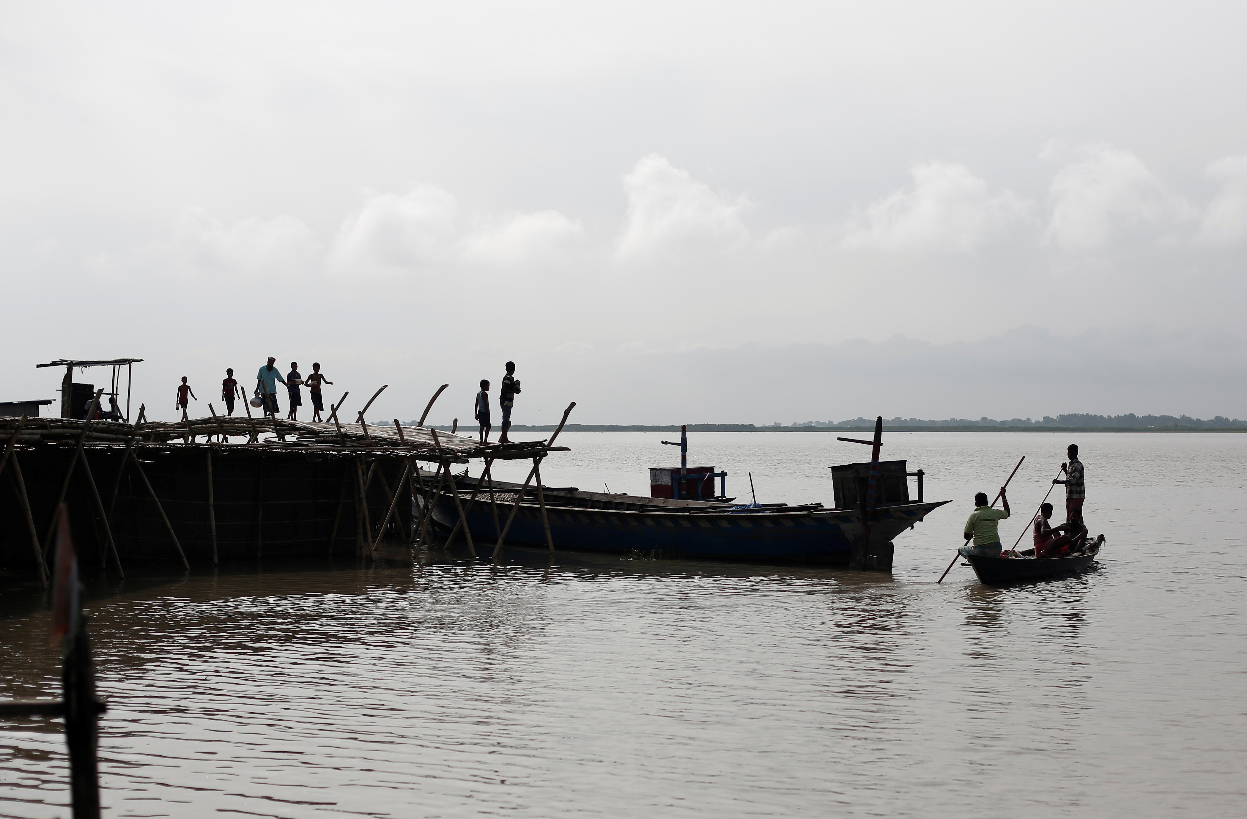 People arrive at a port from their villages in Dhubri district