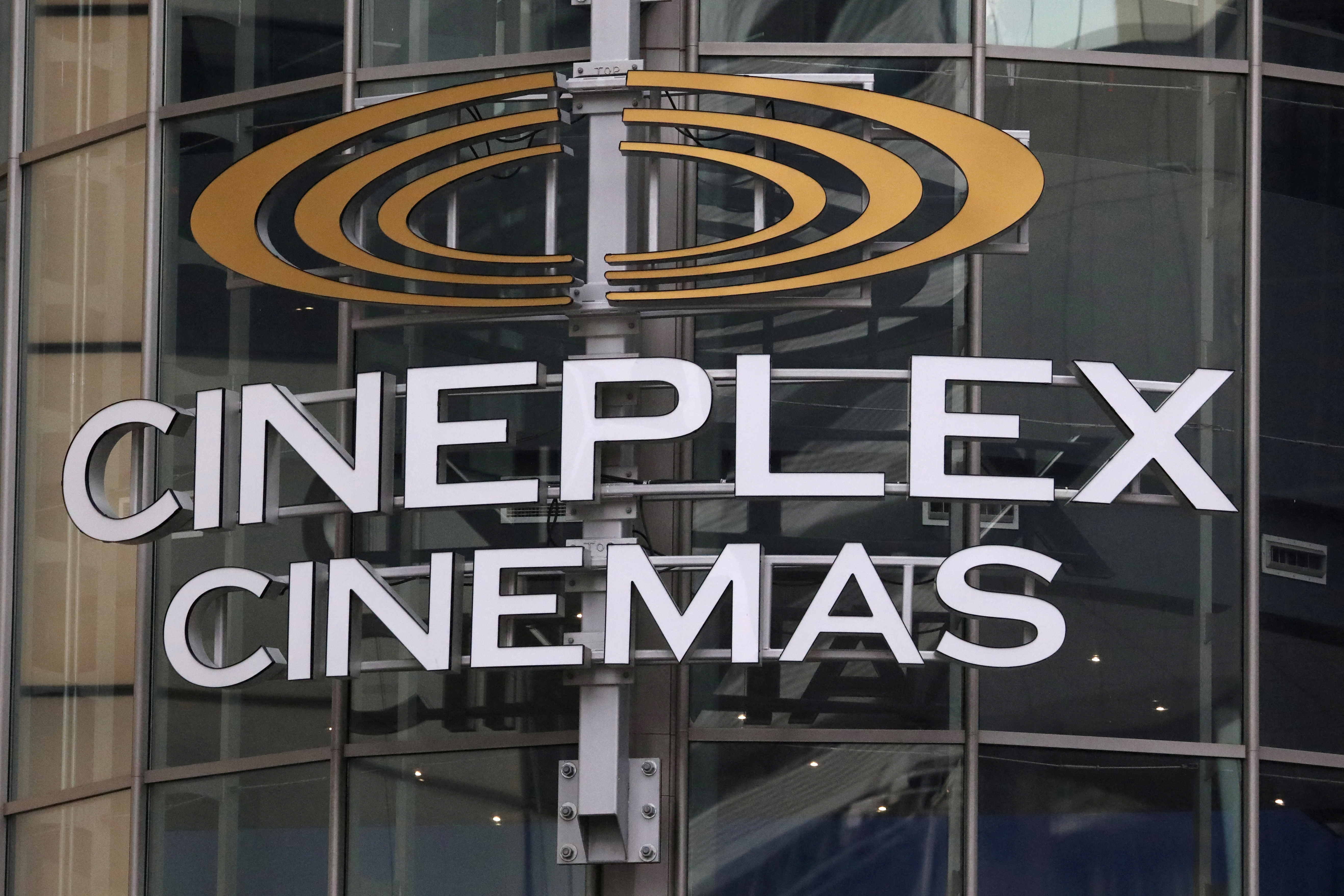 A Cineplex movie theatre sign looms over Yonge street in Toronto