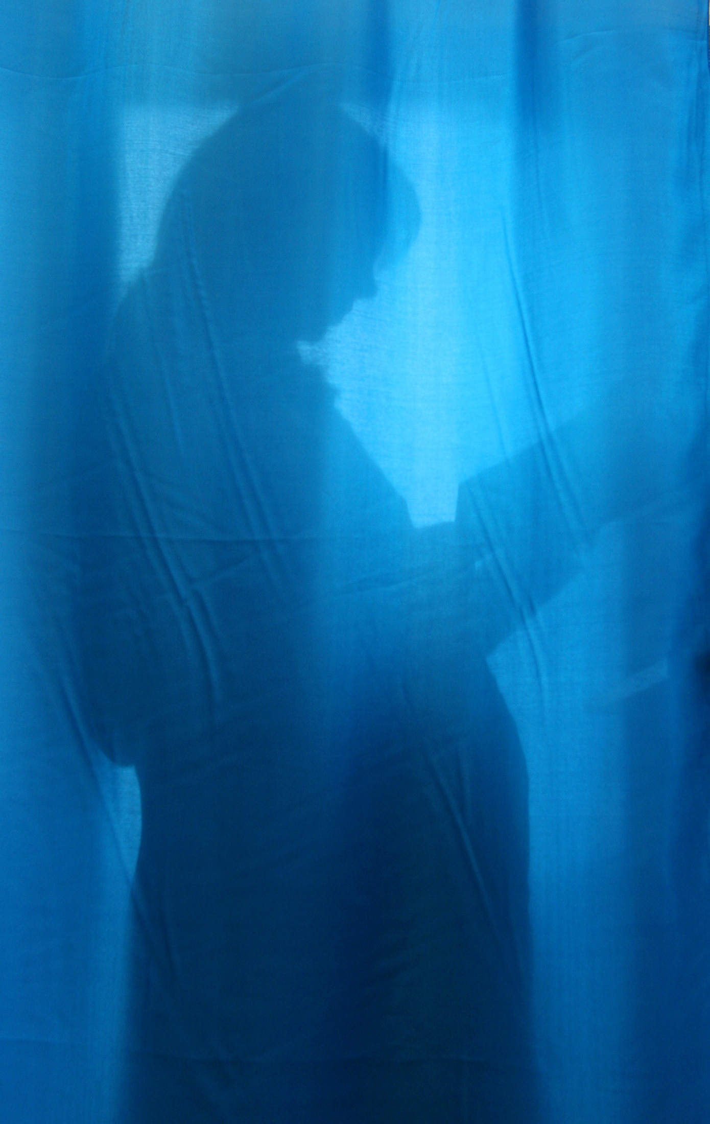 A pregnant woman is seen through the curtain at a maternity hospital in the Ukrainian capital Kyiv
