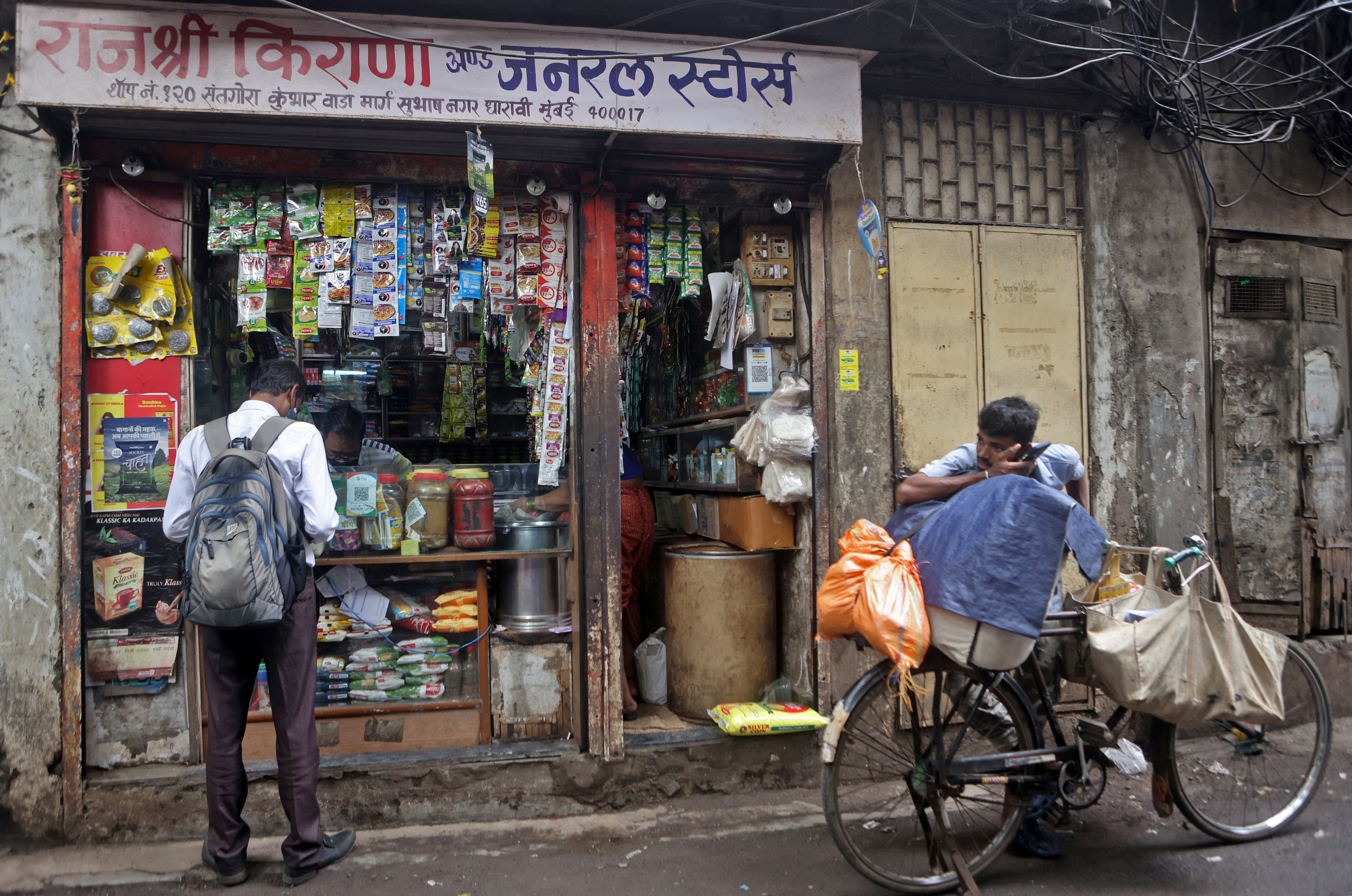 Shivkumar Singh speaks with a sales representative at his store in Dharavi , Mumbai