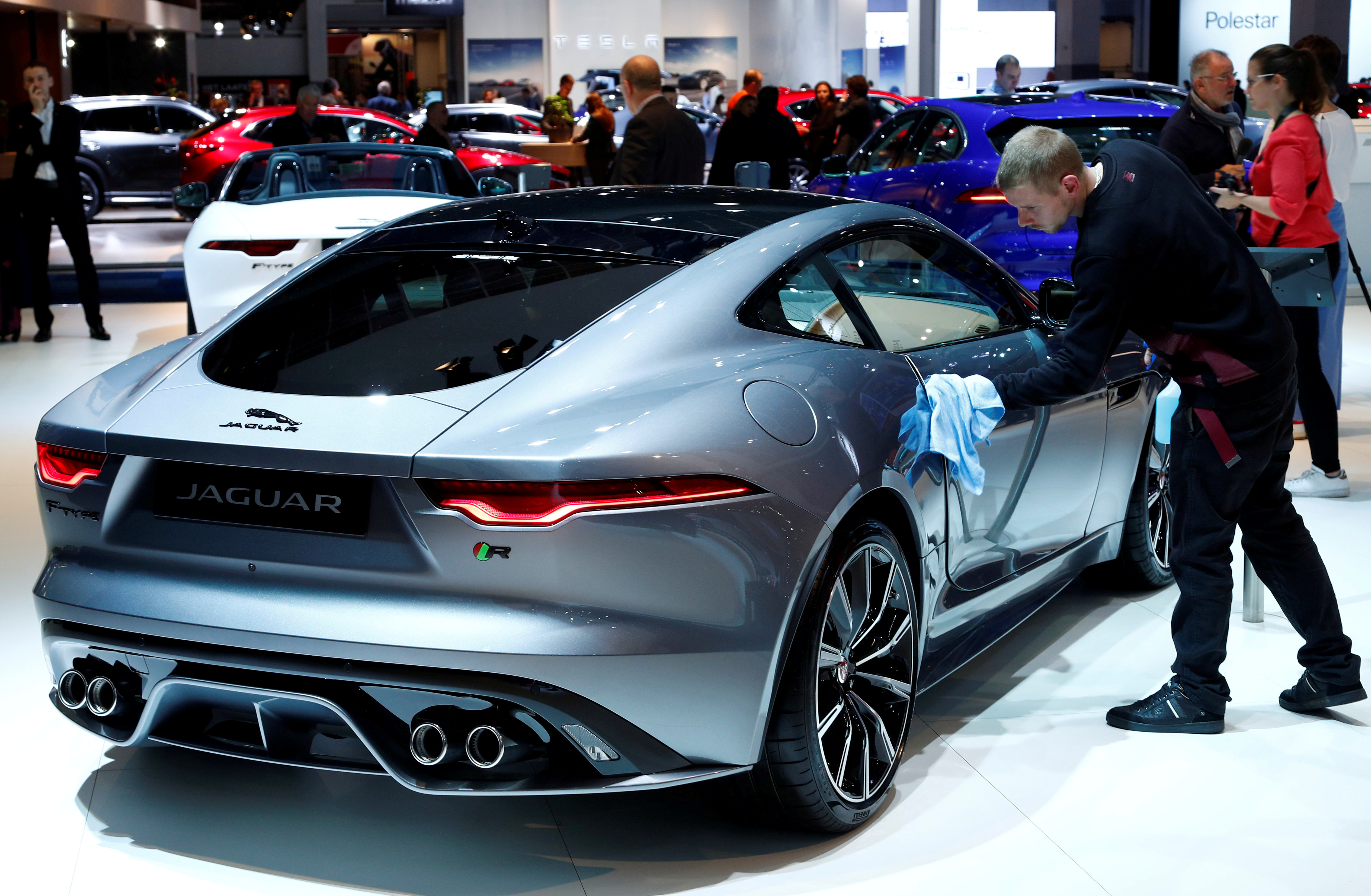 A worker cleans a new Jaguar F-Type model at Brussels Motor Show