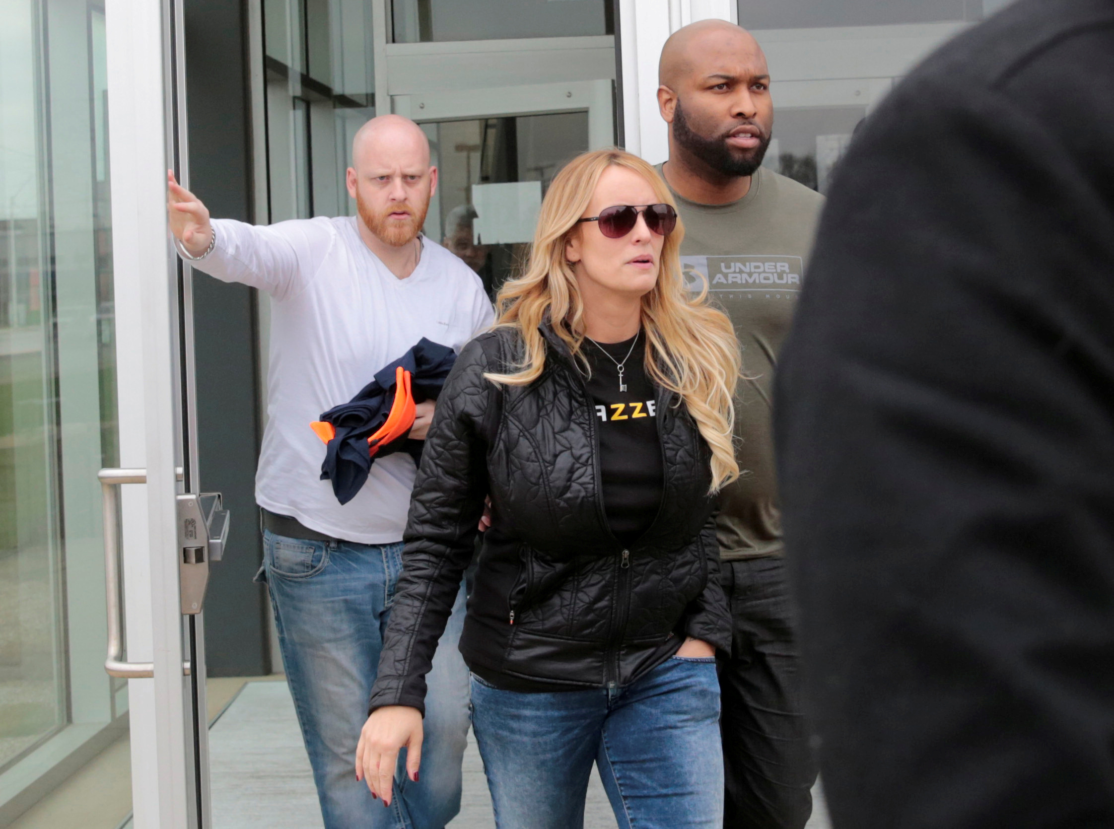 Adult film star Stormy Daniels and her security leave the Detroit Police Department 4th Precinct after picking up her temporary Dance Permit license to perform at a club in Detroit