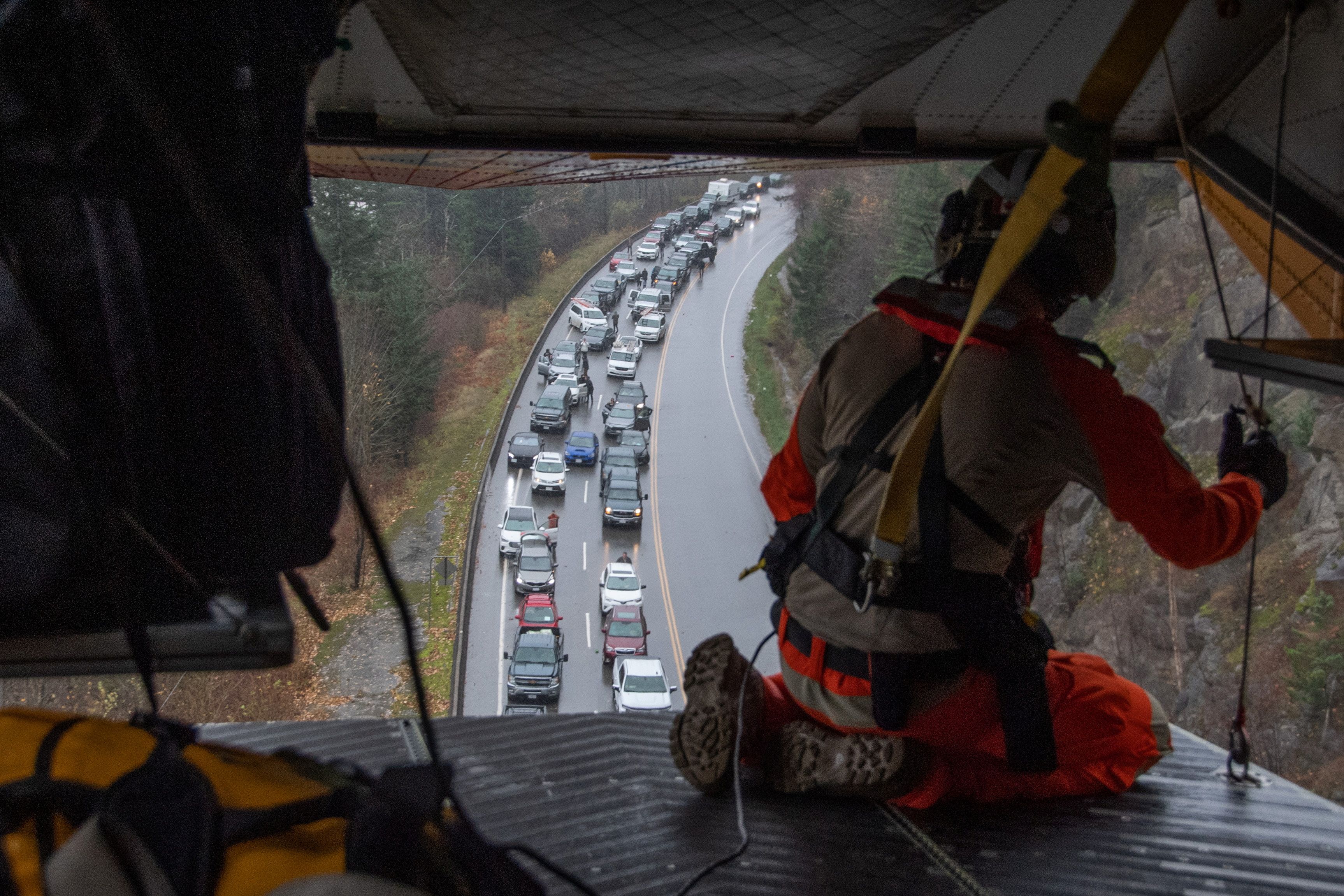 A crew member from a Royal Canadian Air Force 442 Squadron CH-149 Cormorant helicopter views a line of vehicles during the rescue of over 300 motorists stranded by mudslides, in Agassiz, British Columbia, Canada November 15, 2021.  RCAF/Handout via REUTERS 