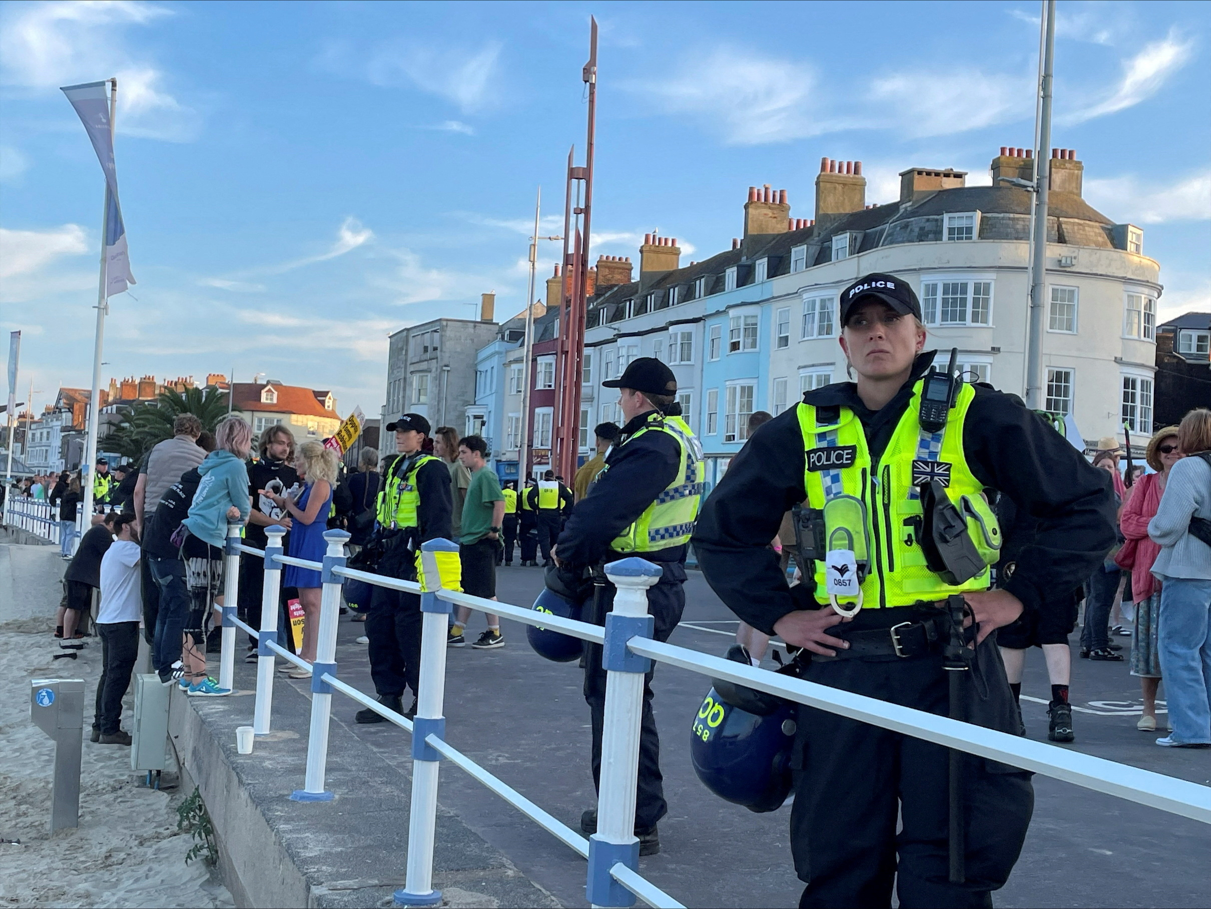 Police wearing riot protection equipment patrol the seafront esplanade following an anti-immigration protest in Weymouth