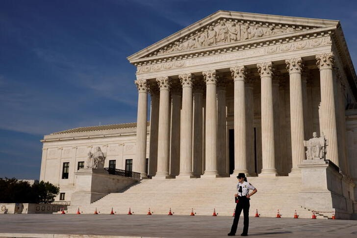A U.S. Supreme Court police officer patrols the plaza in front the court building in Washington