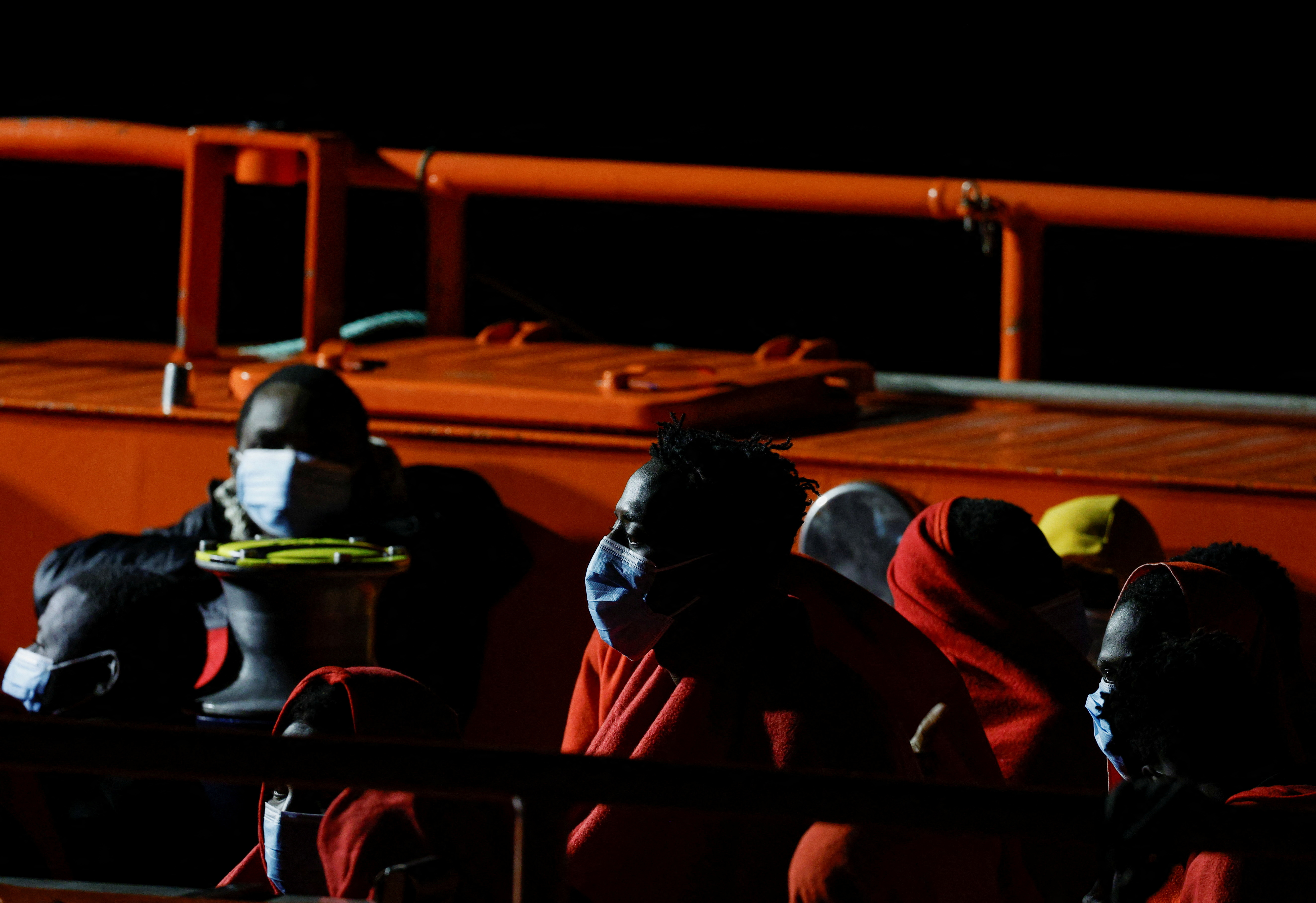 Migrants wait to disembark from a Spanish coast guard vessel, in the port of Arguineguin