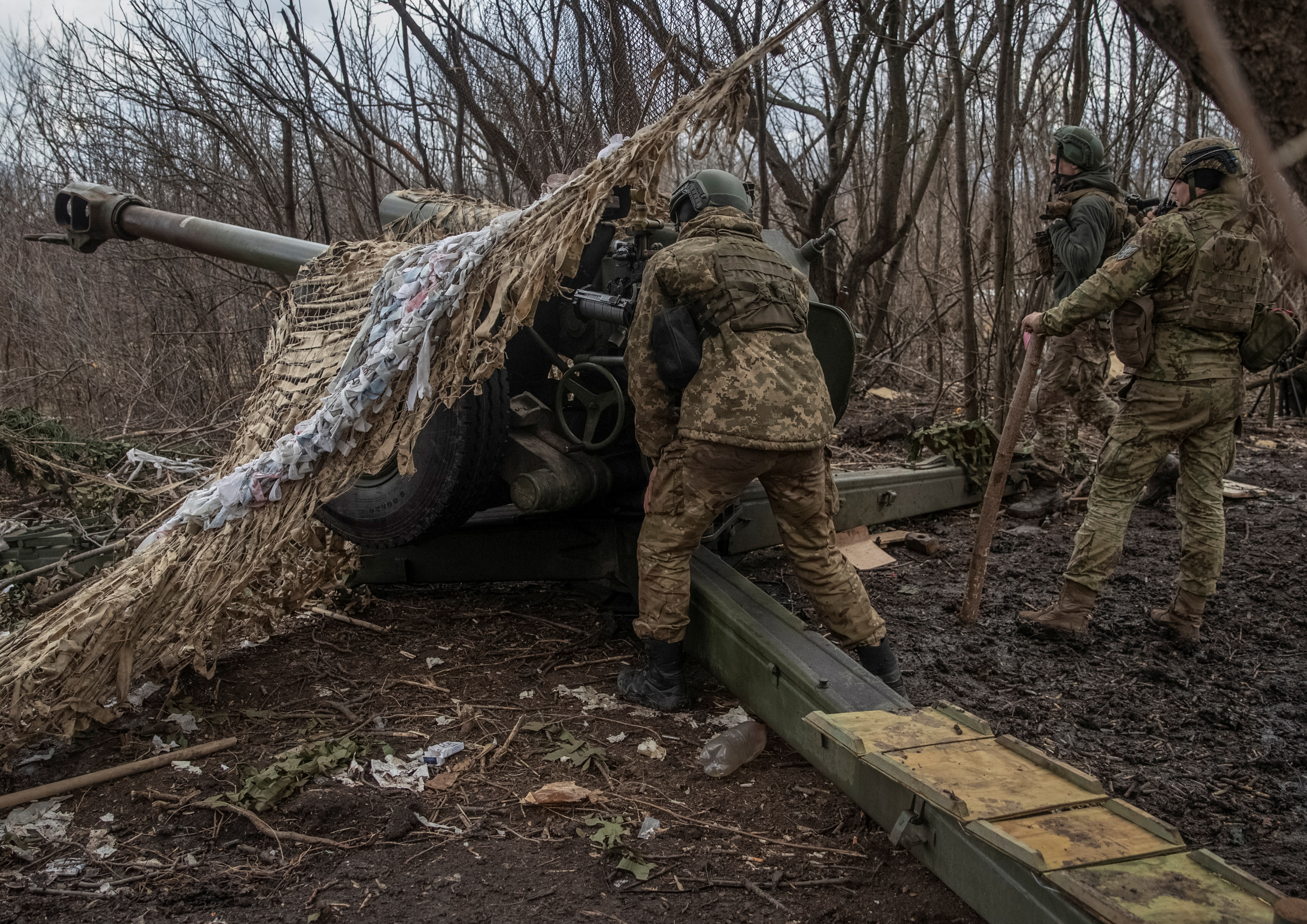 Ukrainian service members prepare to shoot from a howitzer at a front line near the city of Bakhmut