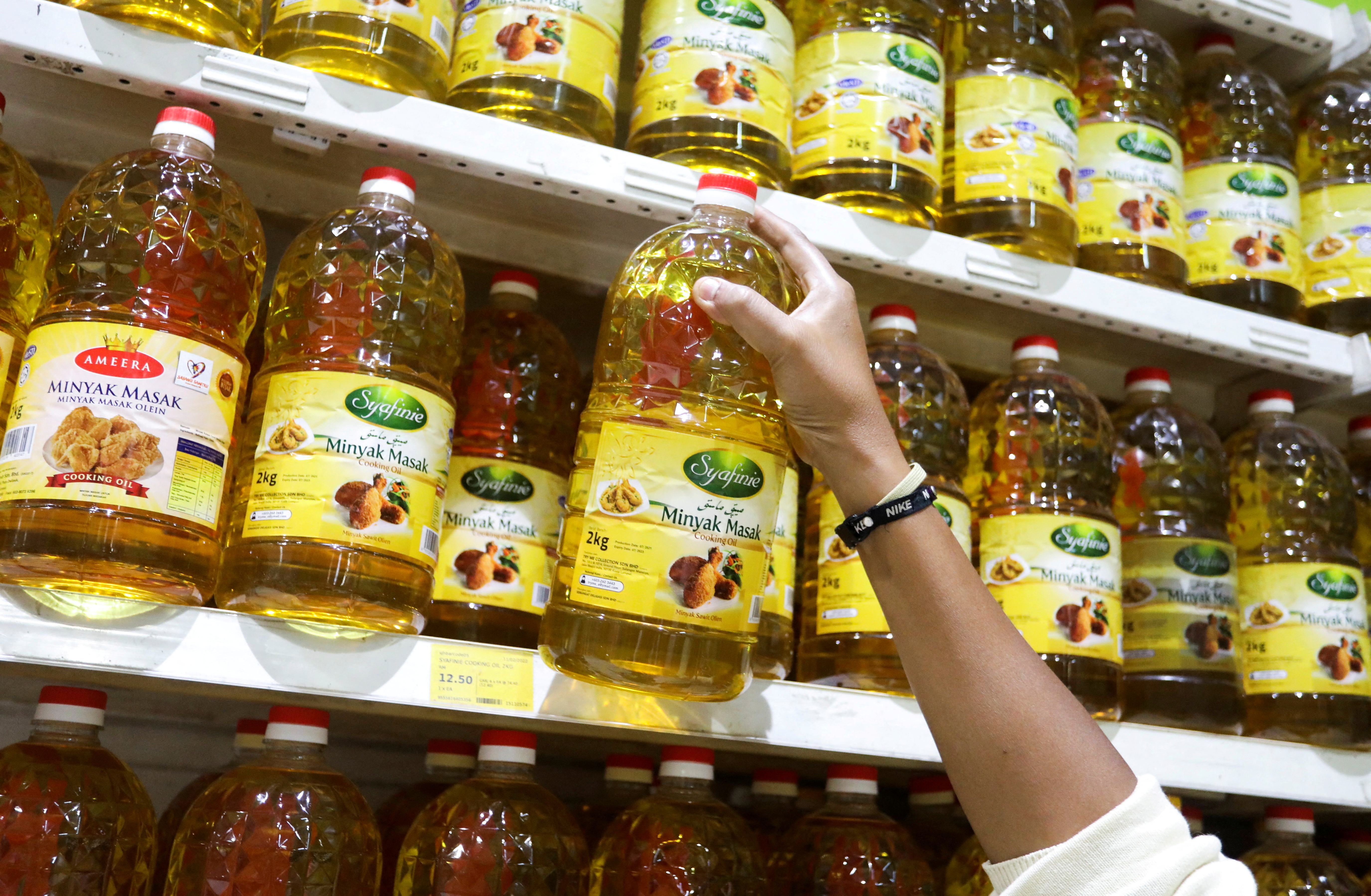 Bottles of cooking oil made from oil palms are displayed at a supermarket in Subang Jaya