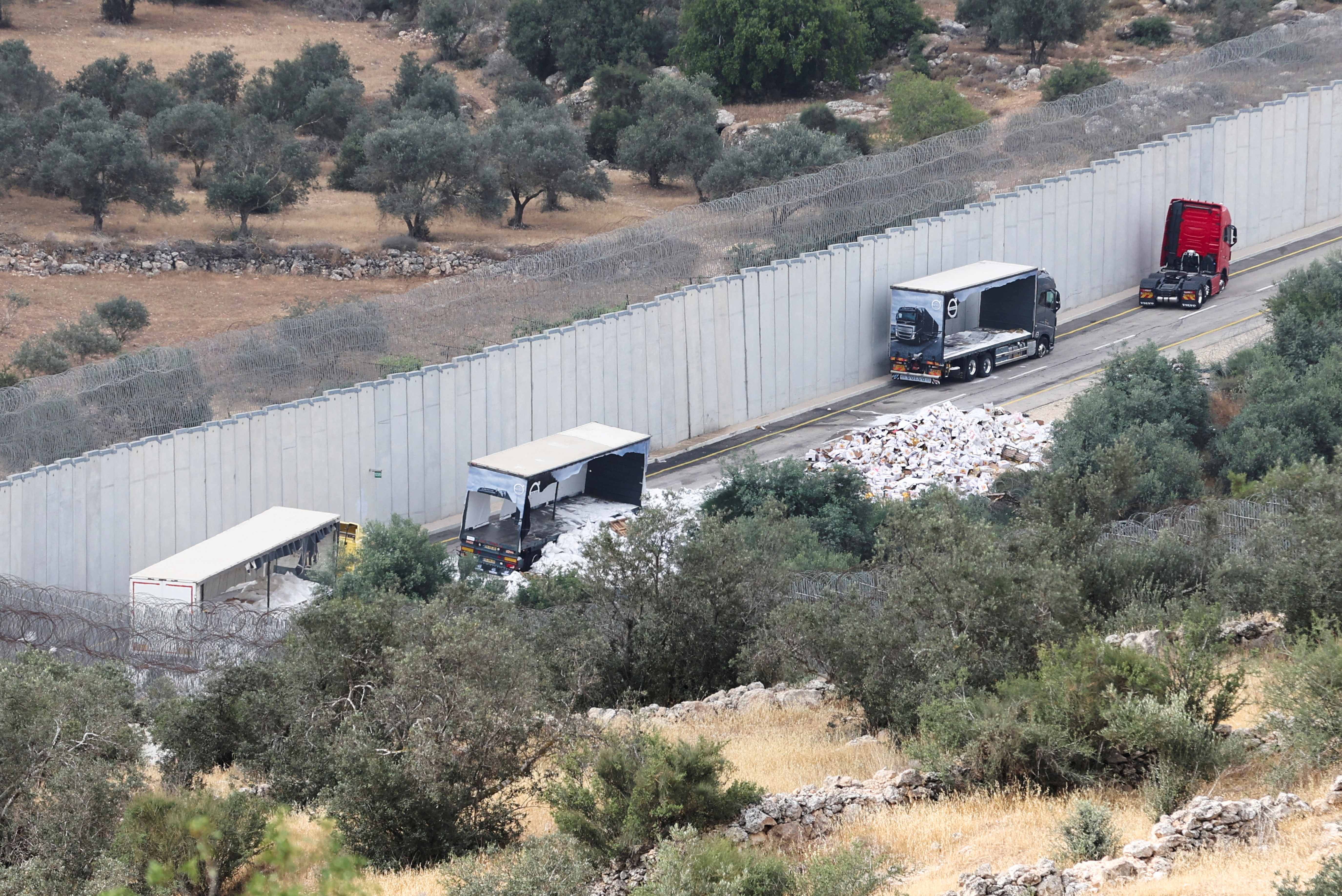 Trucks carrying aid to Gaza stand damaged at checkpoint near Hebron