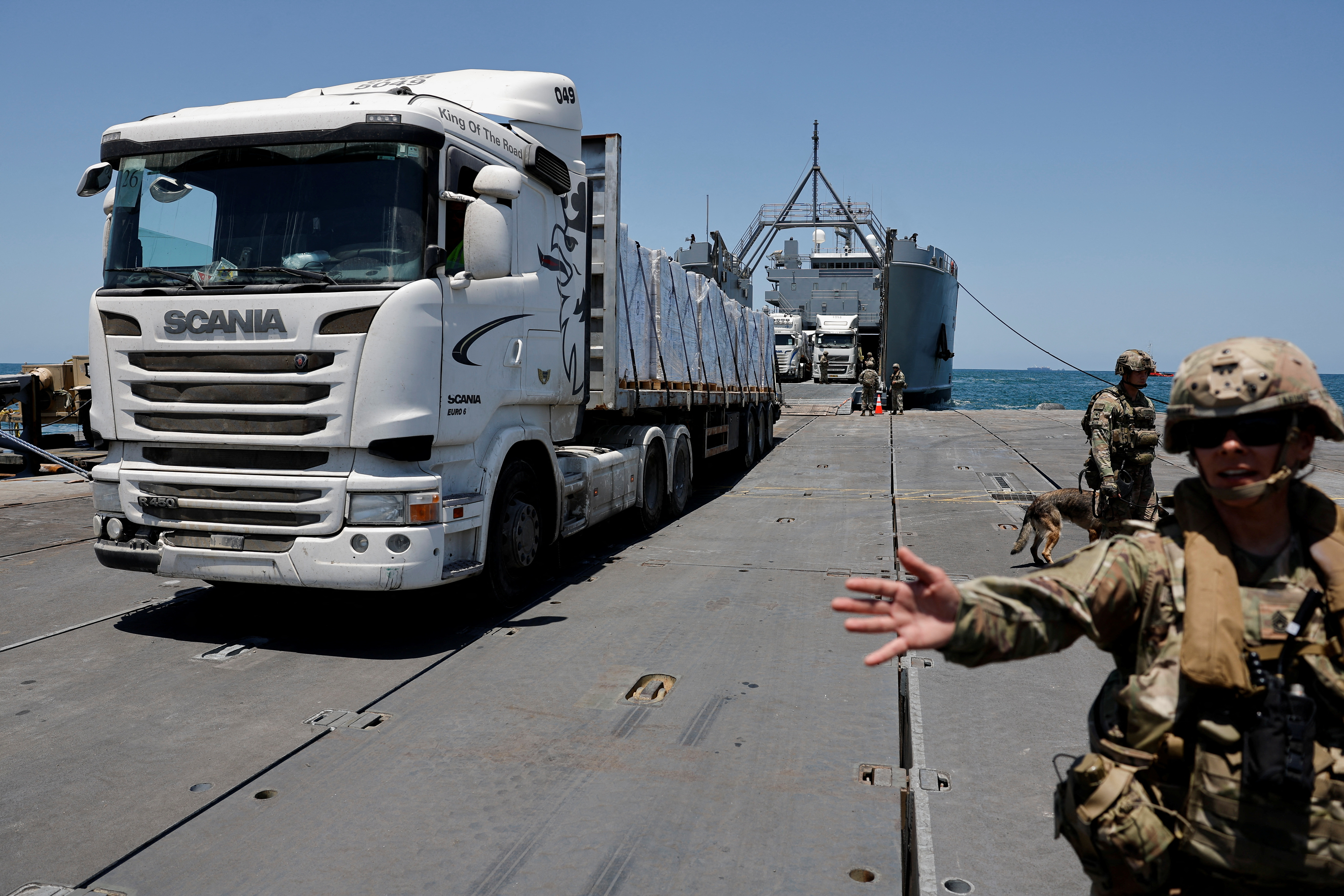 Trucks carry humanitarian aid across Trident Pier