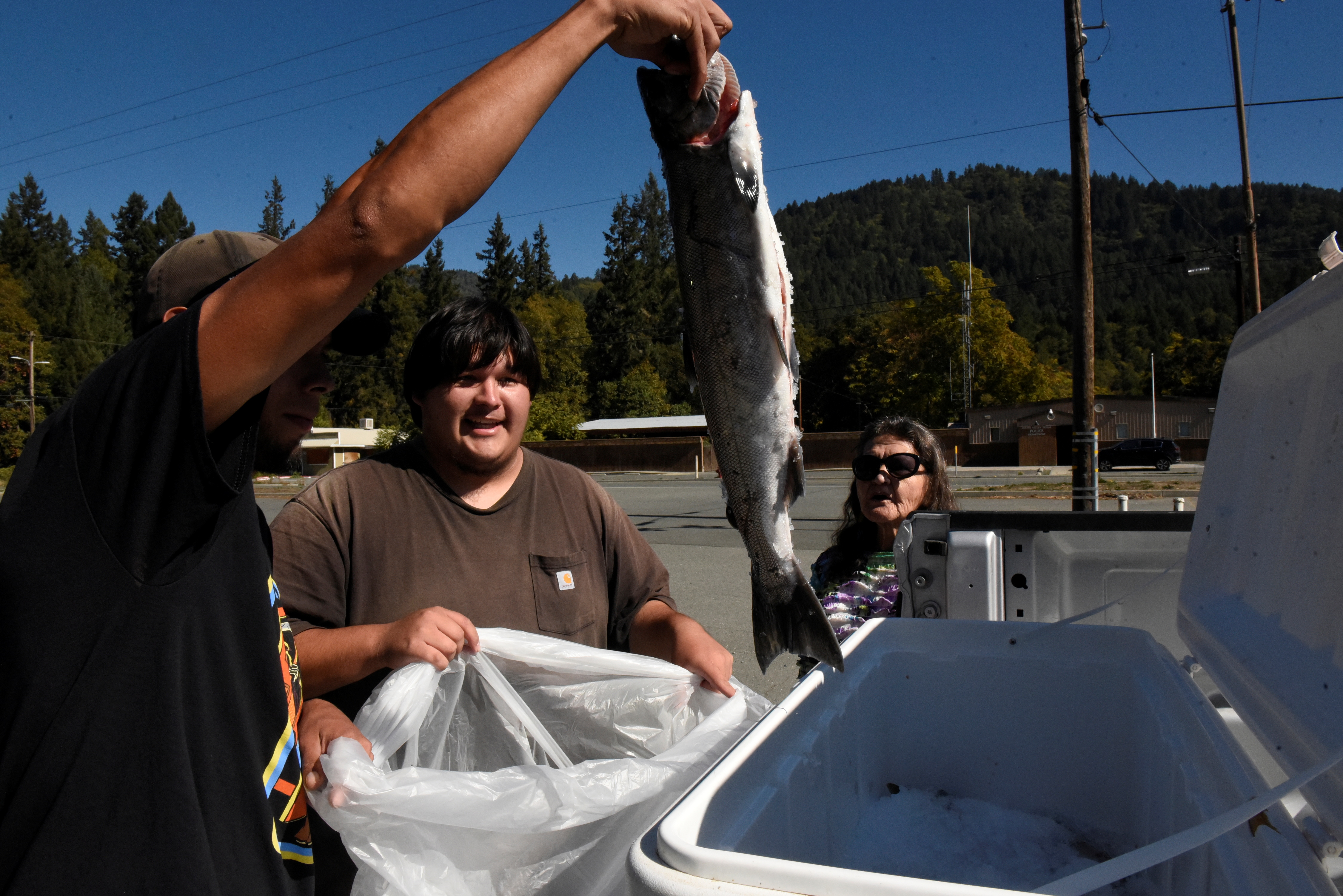 AmeriCorps volunteers show a tribal member a salmon caught by the tribe and available for free on the Hoopa Valley Reservation. REUTERS/Stephanie Keith 