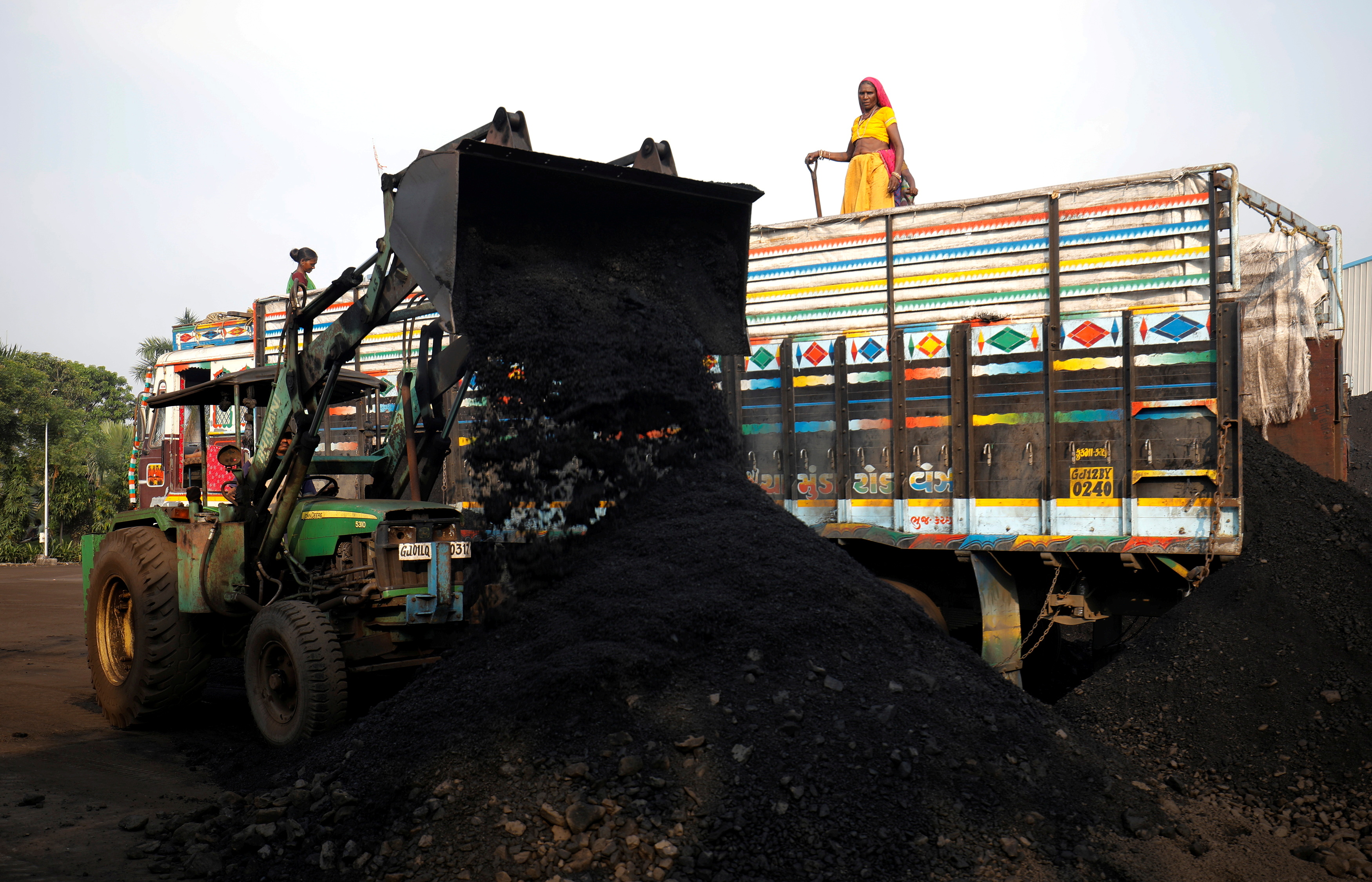 Workers unload coal from a supply truck at a yard on the outskirts of Ahmedabad, India October 12, 2021. REUTERS/Amit Dave/File Photo
