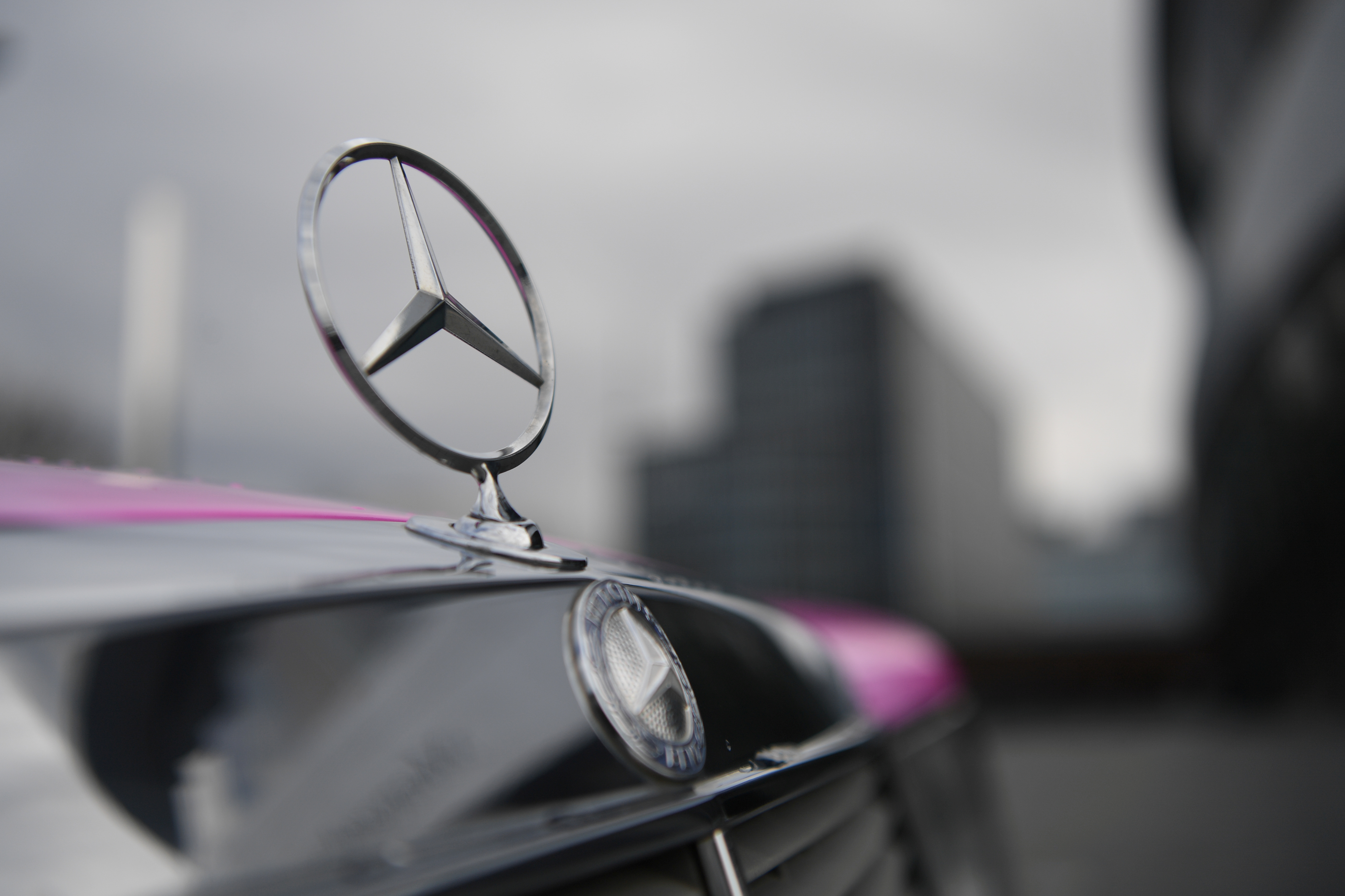 The Mercedes-Benz logo is seen on a car in front of the Mercedes-Benz Museum in Stuttgart