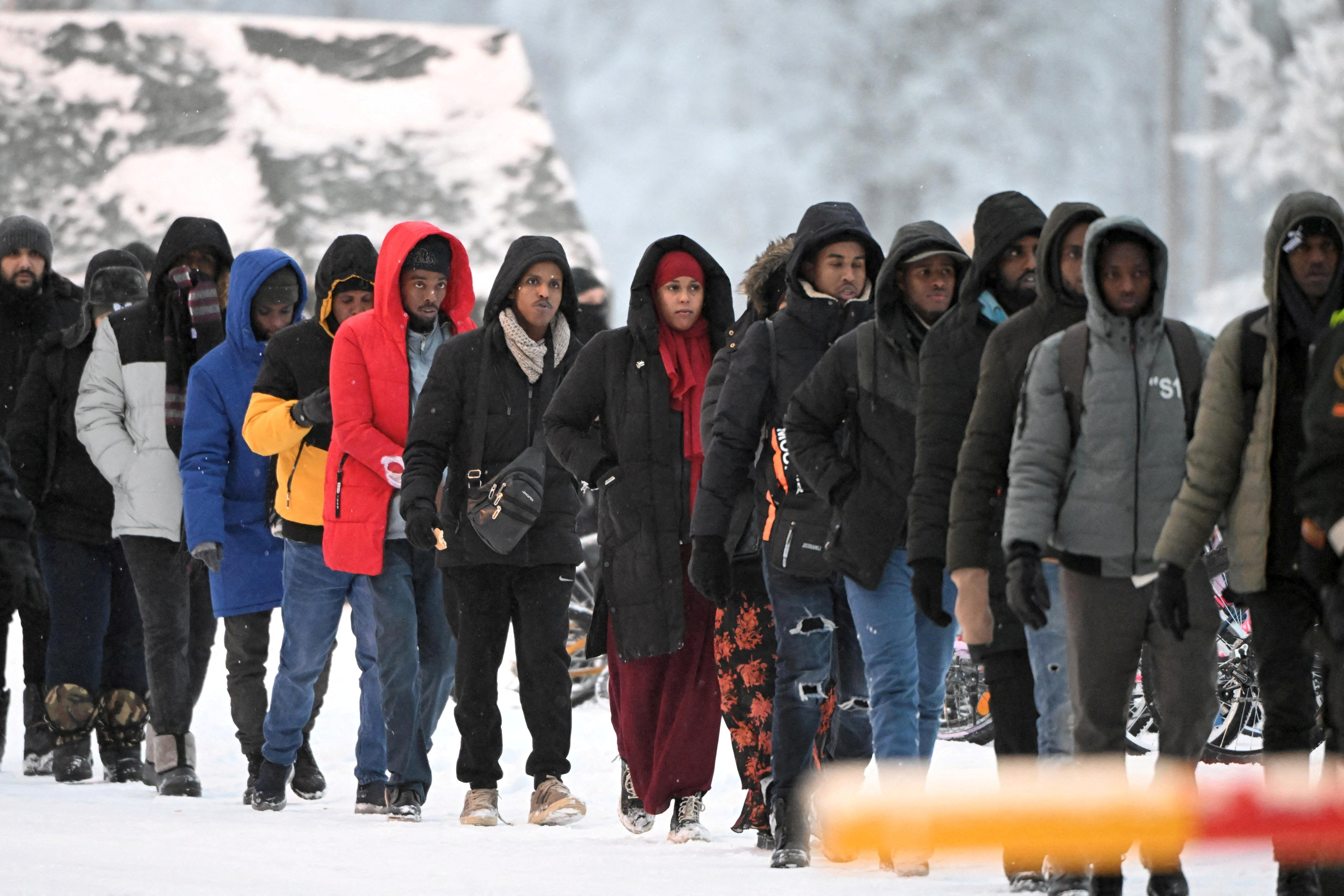 Group of migrants arrive to the international border crossing at Salla