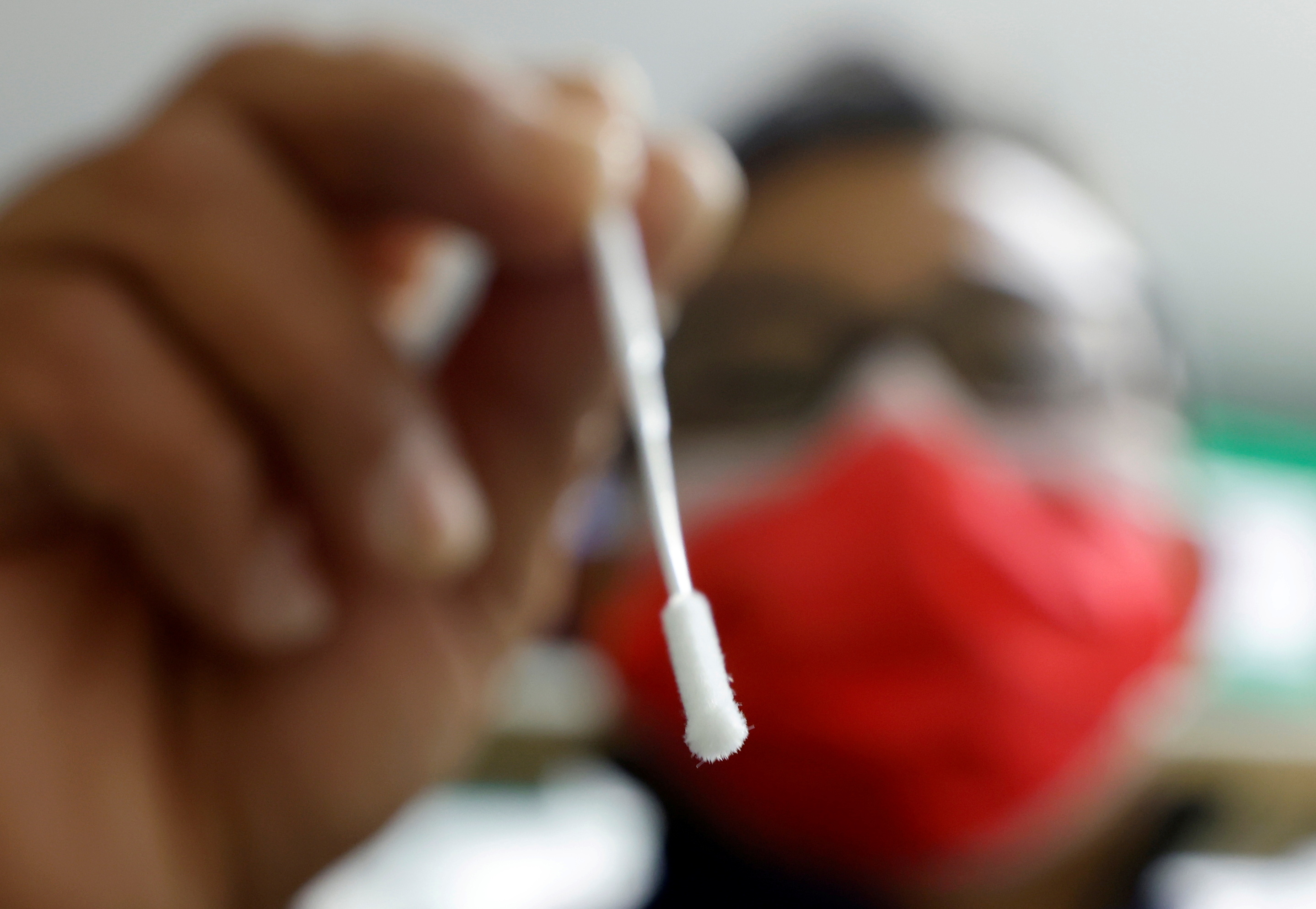 A medical worker holds a nasal swab for a coronavirus disease (COVID-19) test in a pharmacy in Nice, France, November 25, 2021.   REUTERS/Eric Gaillard