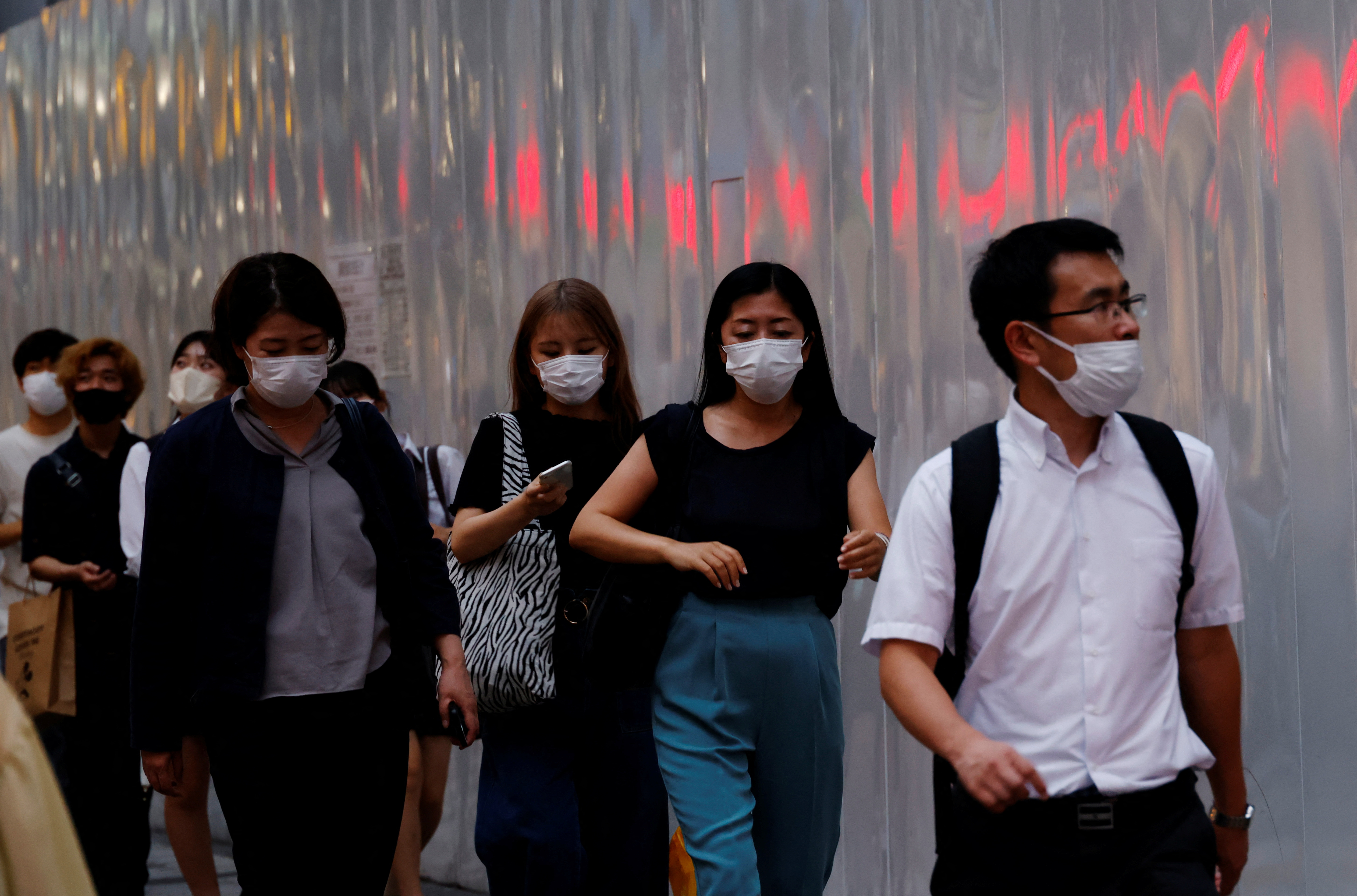 People wearing protective masks amid the coronavirus disease (COVID-19) outbreak, make their way in Tokyo