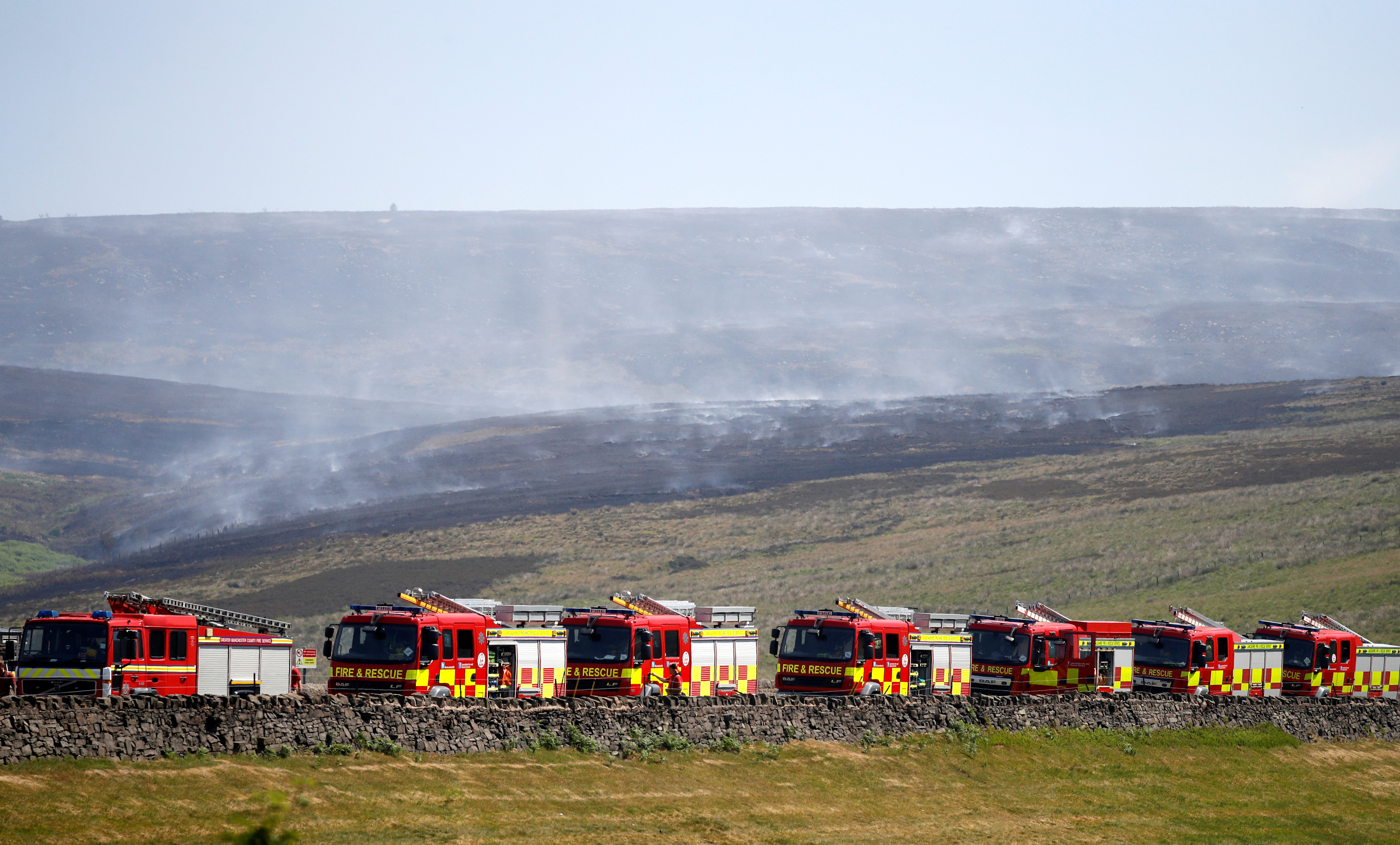 Fire engines park up on the moor as firefighters continue tackling a blaze on Saddleworth Moor