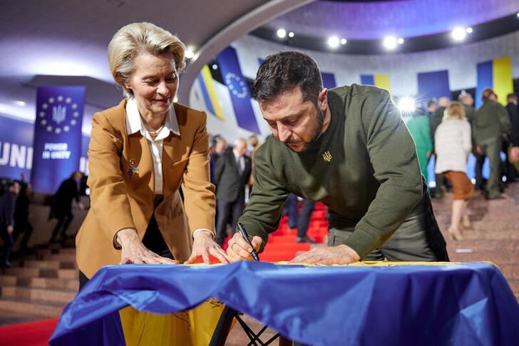 Ukraine's President Zelenskiy and European Commission President von der Leyen sign a Ukrainian national flag before start of EU summit in Kyiv