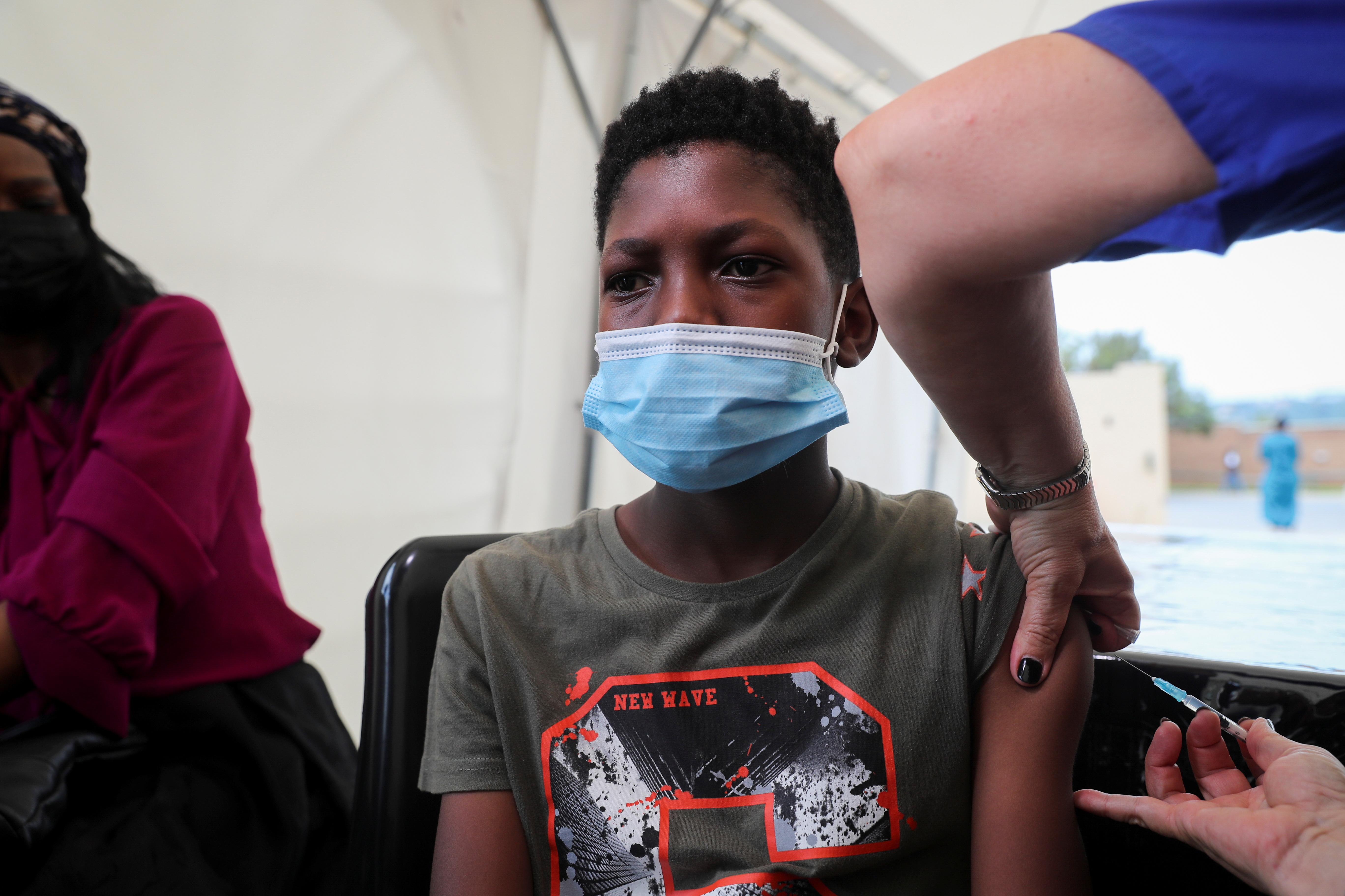 A healthcare worker administers the Pfizer coronavirus disease (COVID-19) vaccine to Simphiwe, 13, amidst the spread of the SARS-CoV-2 variant Omicron in Johannesburg, South Africa, December 04, 2021. REUTERS/Sumaya Hisham
