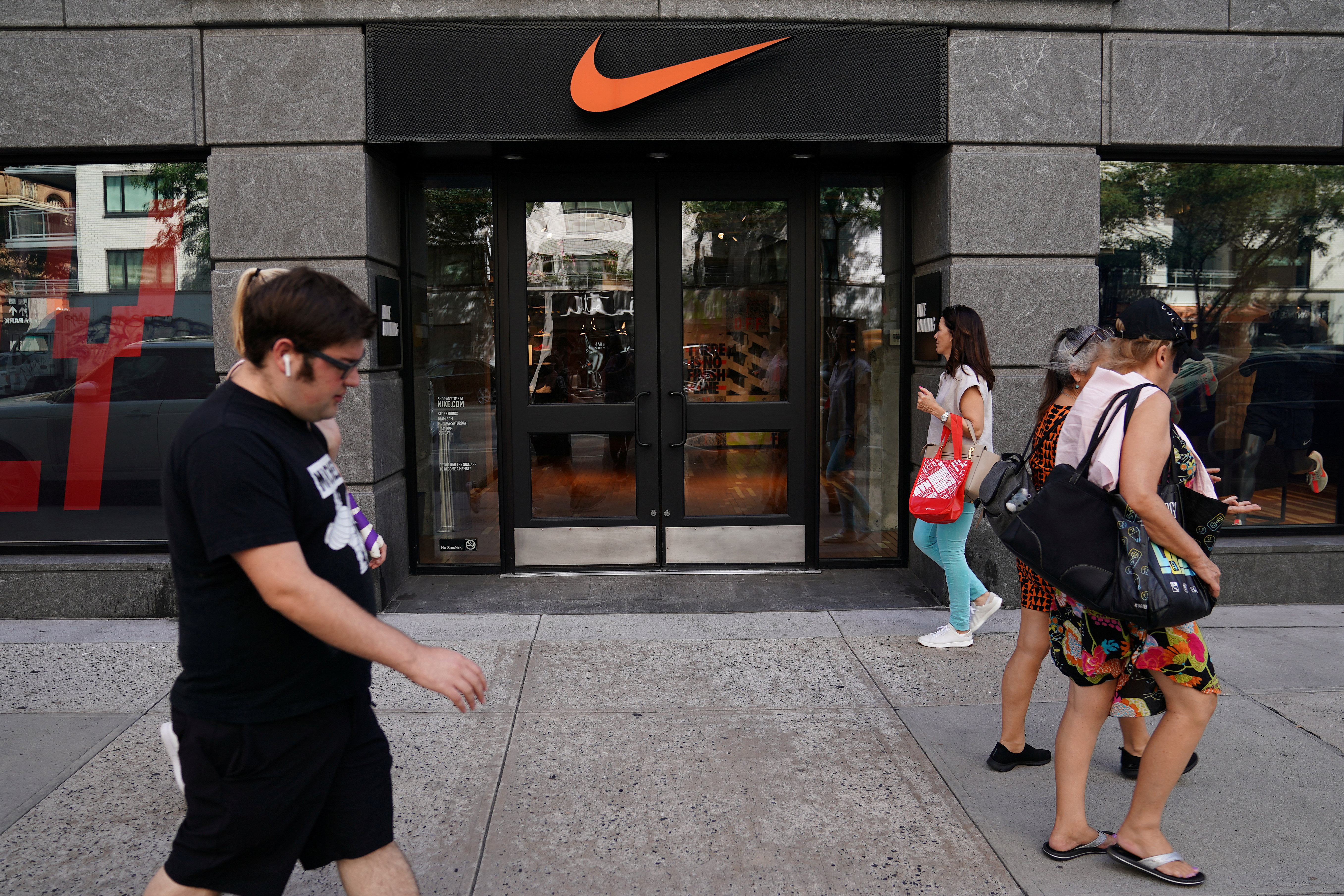 People walk past a Nike store in New York City,