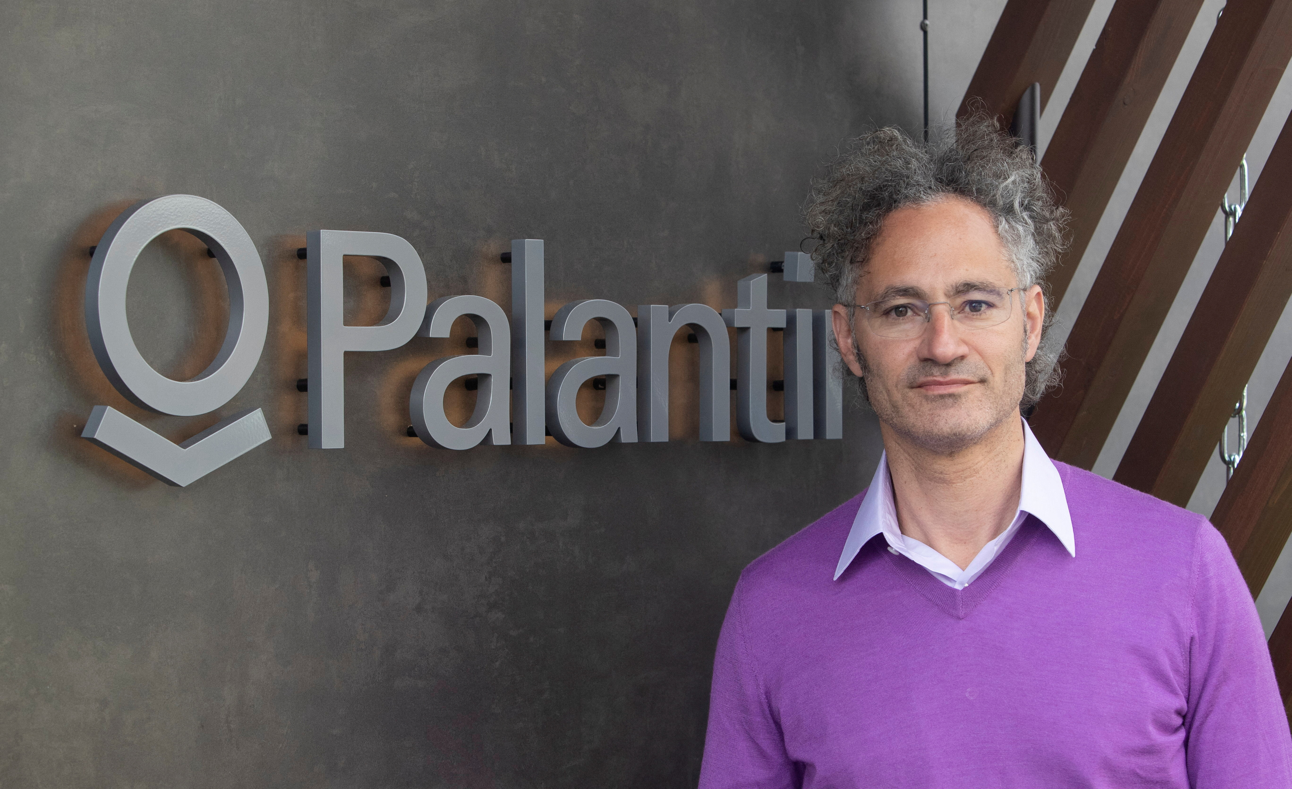 Karp, CEO of Palantir Technologies poses beside the company's logo in Davos