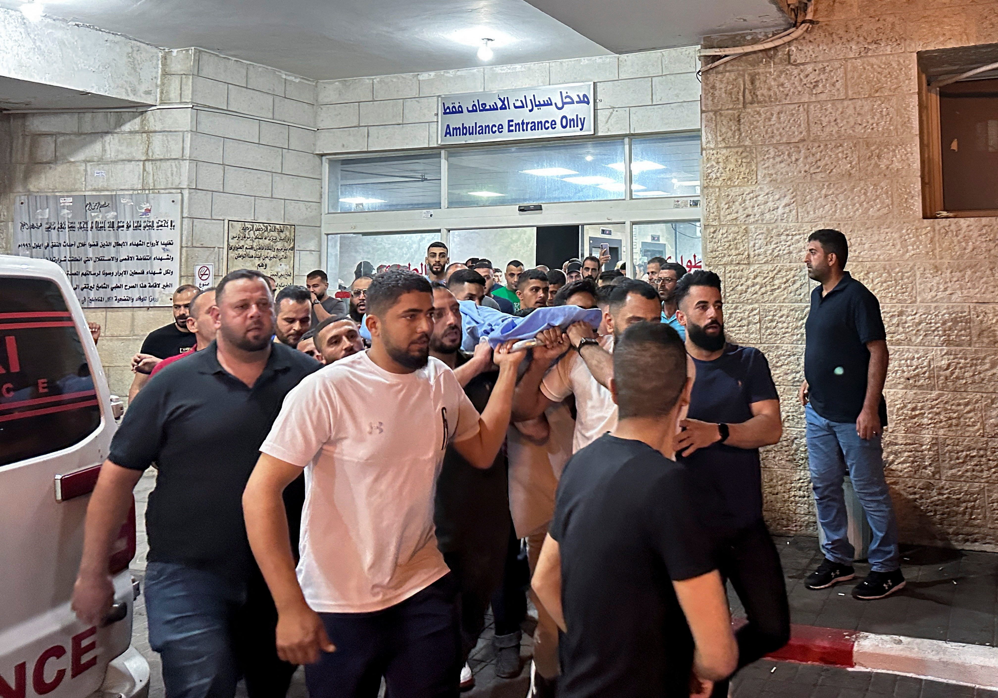 Mourners carry the body of Palestinian who was killed during clashes with Israeli settlers in the West Bank