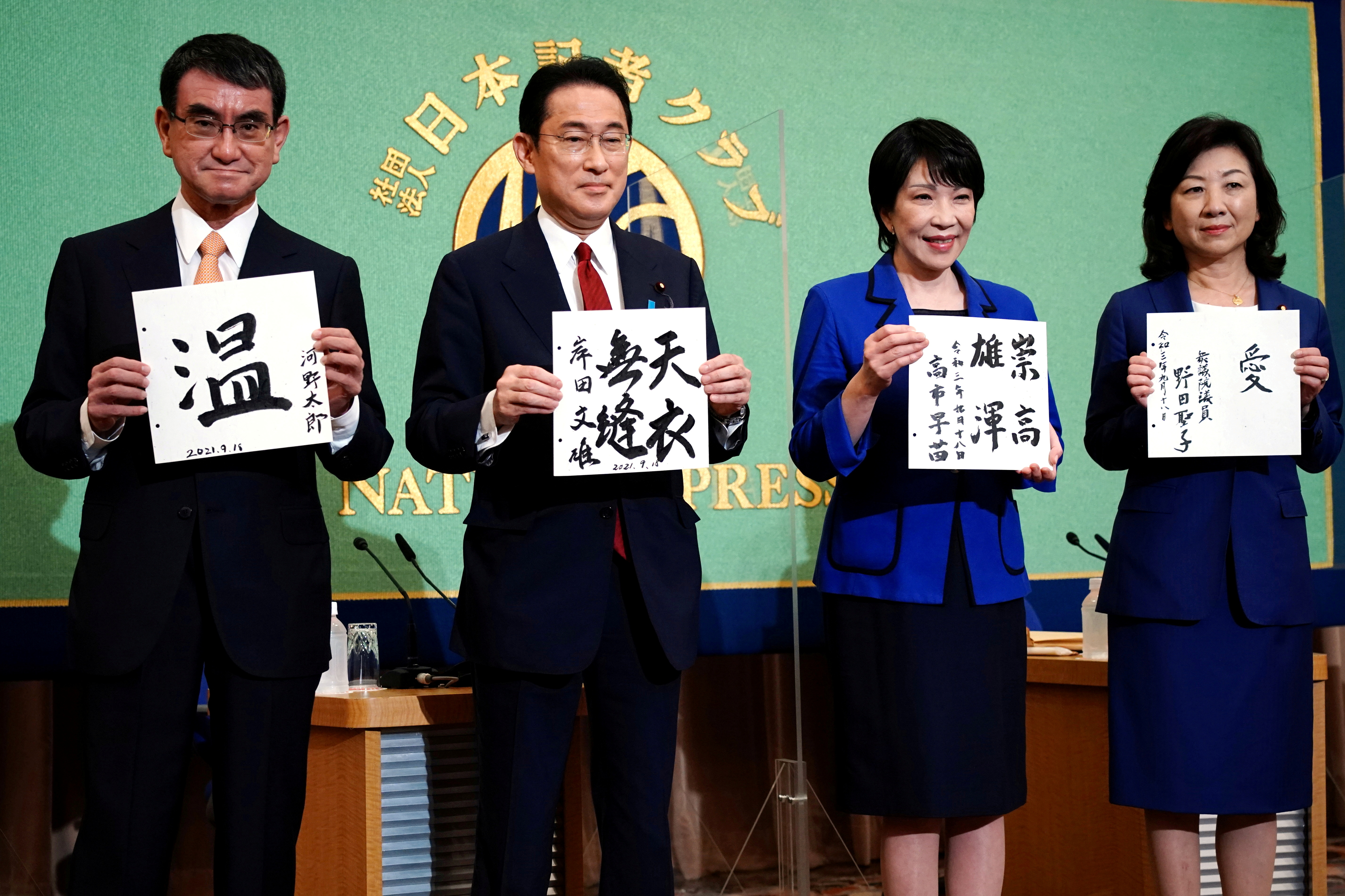 FILE PHOTO: Candidates for the presidential election of the ruling Liberal Democratic Party pose with papers with their sign and words prior to a debate session held by Japan National Press Club
