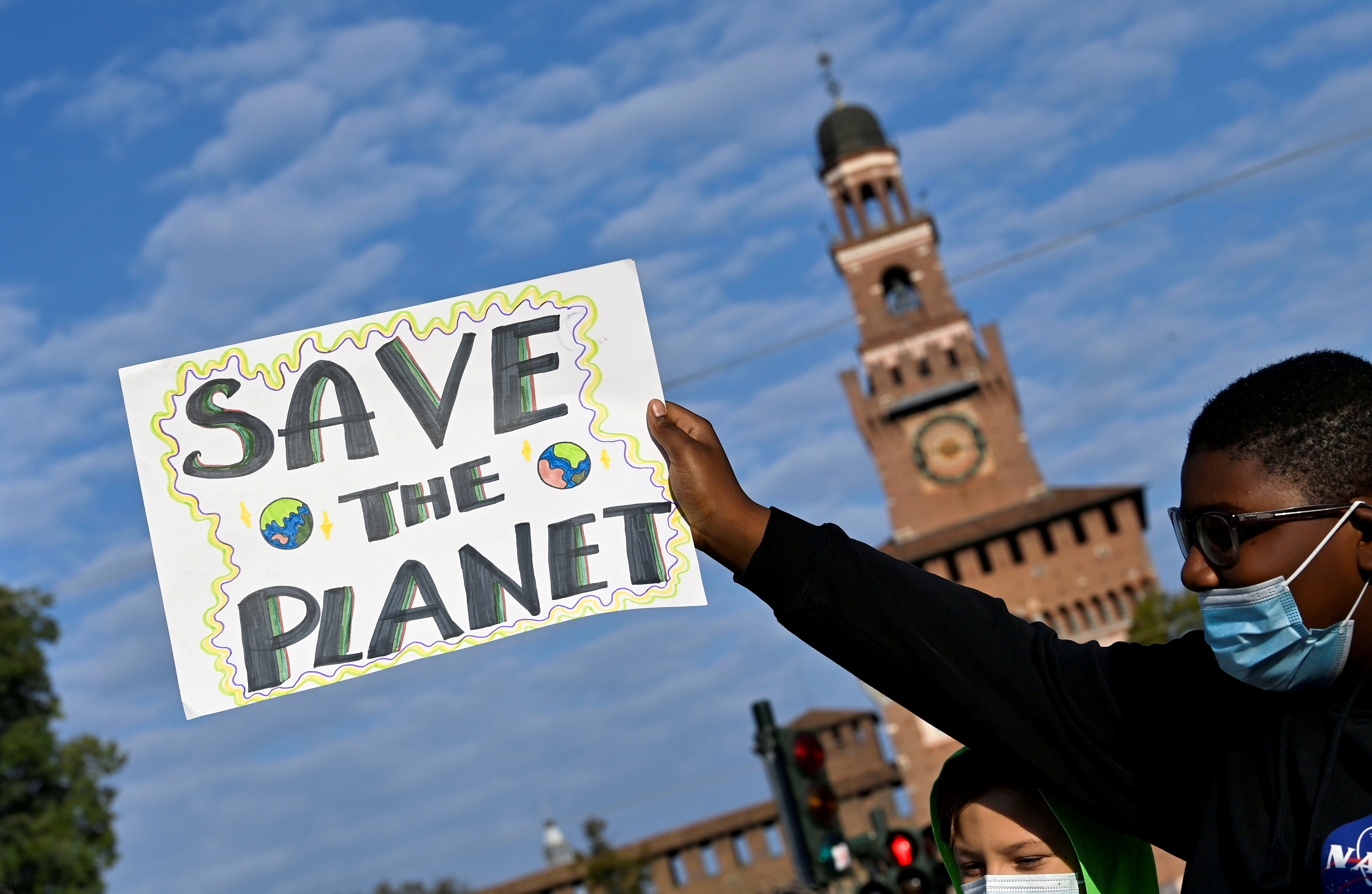 A demonstrator holds up a sign as he attends a Fridays for Future climate strike in Milan, Italy ahead of Glasgow's COP26 meeting