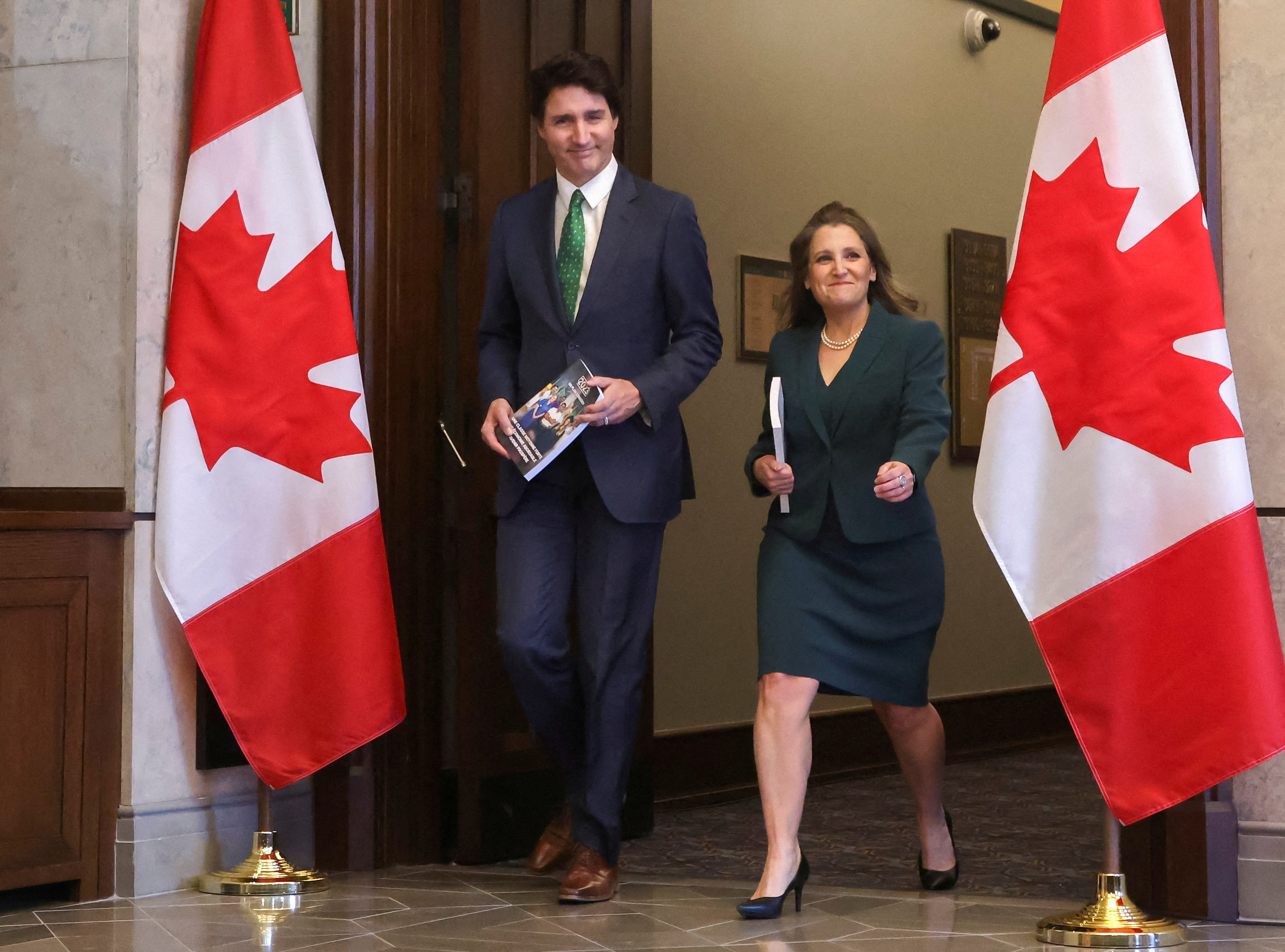 Canada's PM Trudeau and Finance Minister Freeland walk holding the 2023-24 budget in Ottawa