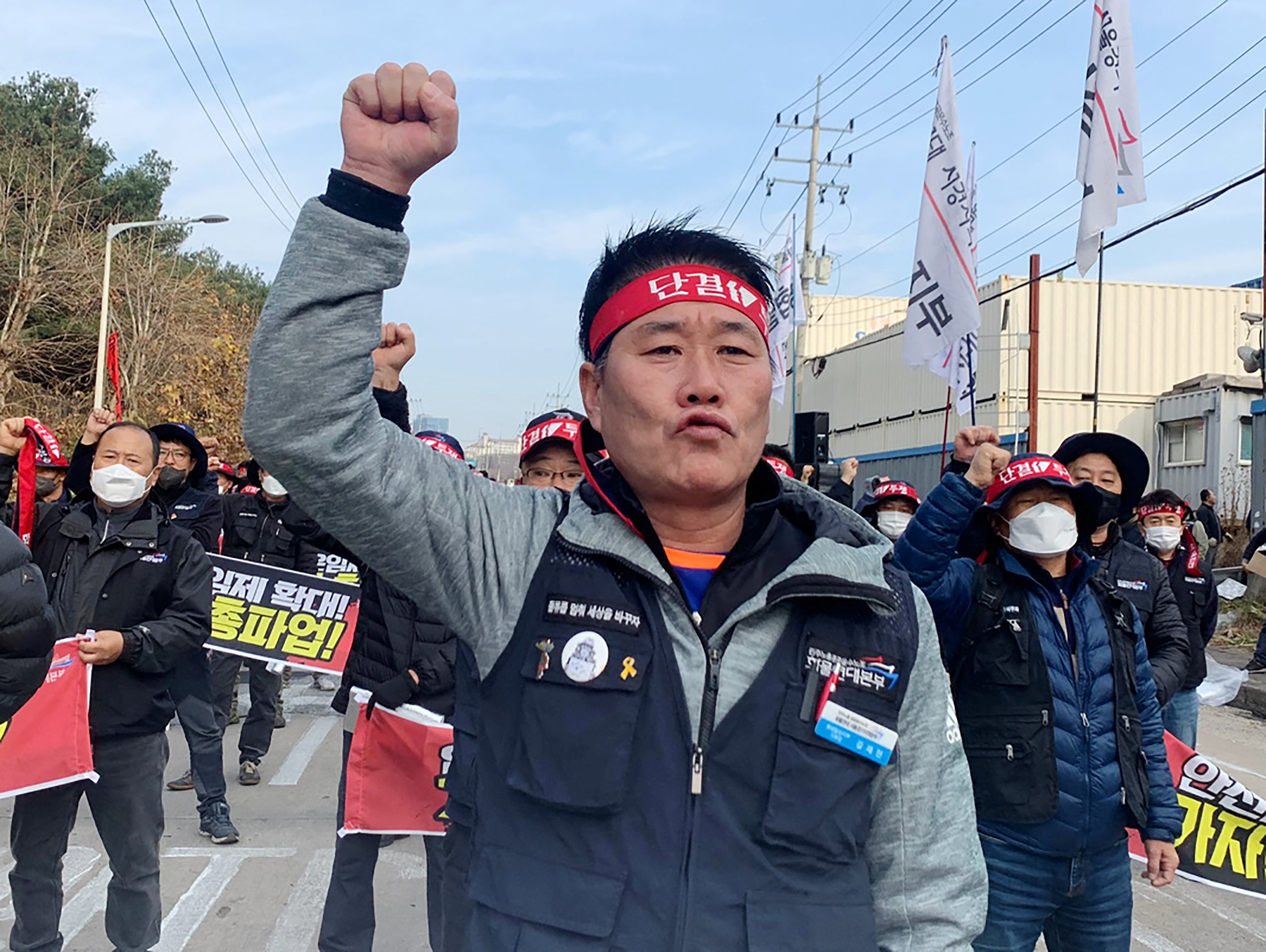Unionized truckers shout slogans during their rally as they kick off their strike in front of transport hub Uiwang