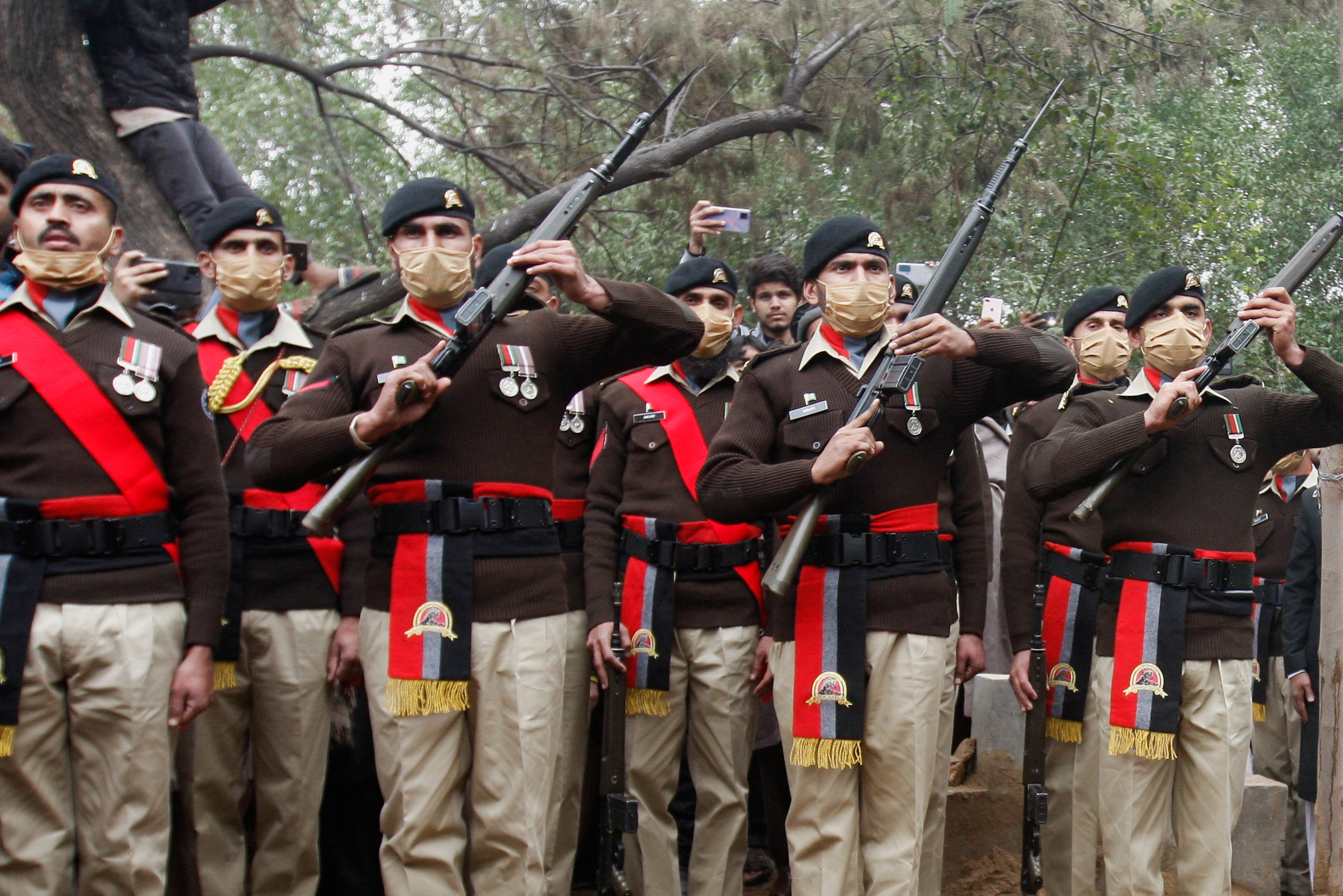 Army soldiers hold their guns to pay tribute to Captain Bilal Khalil, who was killed along with others in an attack on a military base in Nushki, during his funeral in Faisalabad, Pakistan, February 4, 2022. REUTERS/Fayyaz Hussain