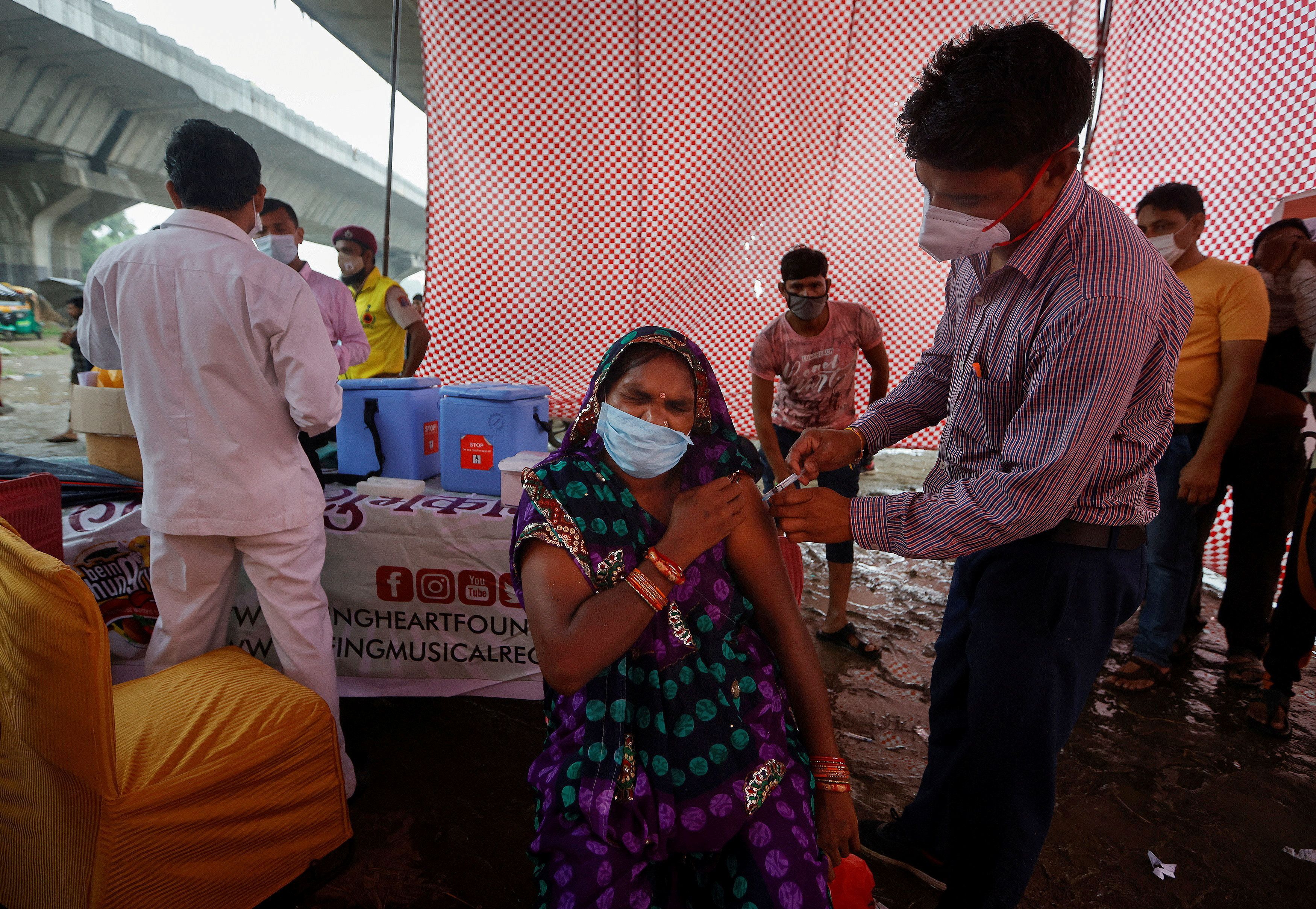 A woman receives a dose of COVAXIN coronavirus disease (COVID-19) vaccine manufactured by Bharat Biotech, during a vaccination drive at an under-construction flyover in New Delhi, India, August 31, 2021. REUTERS/Adnan Abidi/File Photo