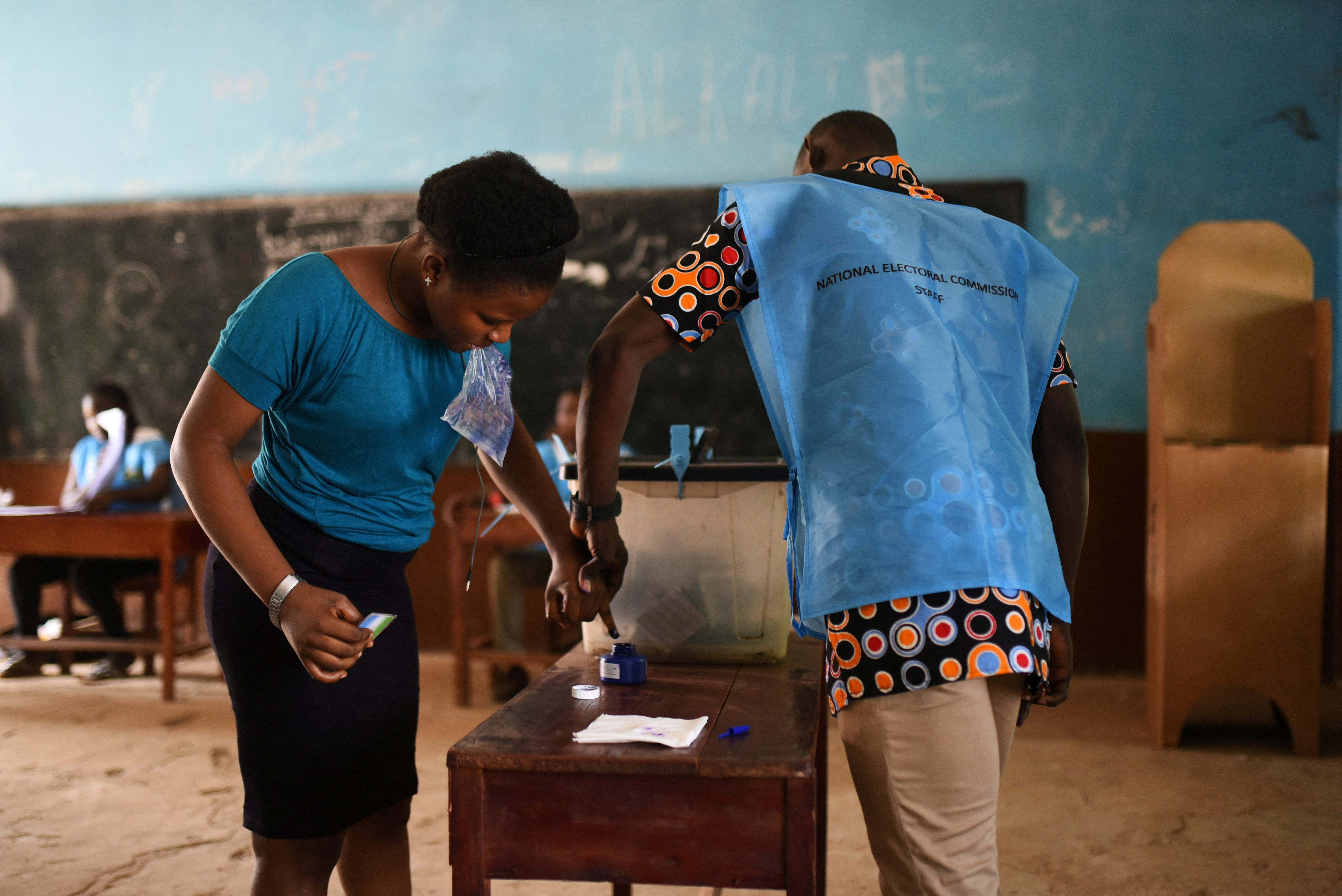 A woman gets her finger inked after casting her vote at a polling station during a presidential run-off in Freetown