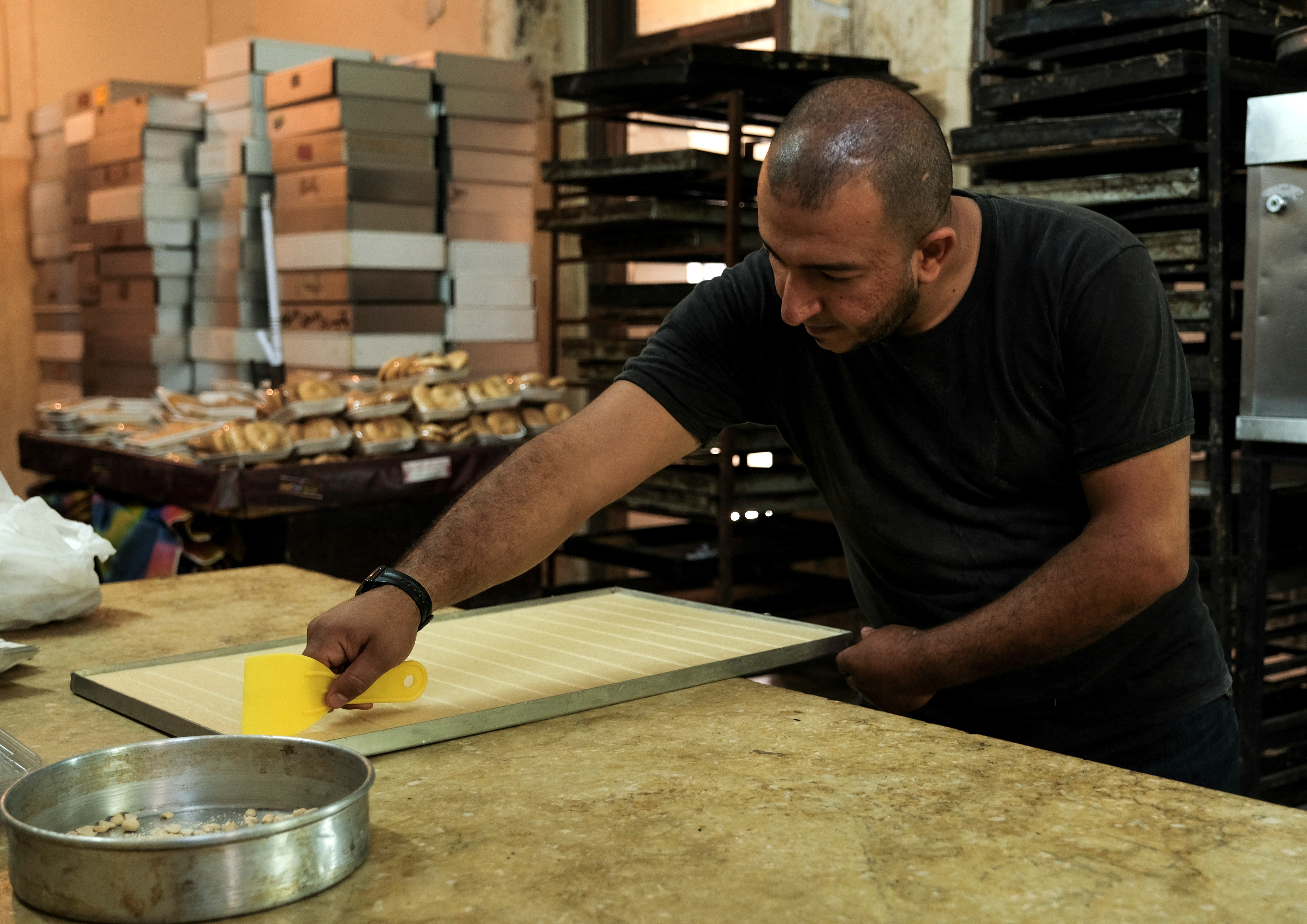 Taha Riz, 33, prepares traditional sweets inside a kitchen of a bakery in Tripoli