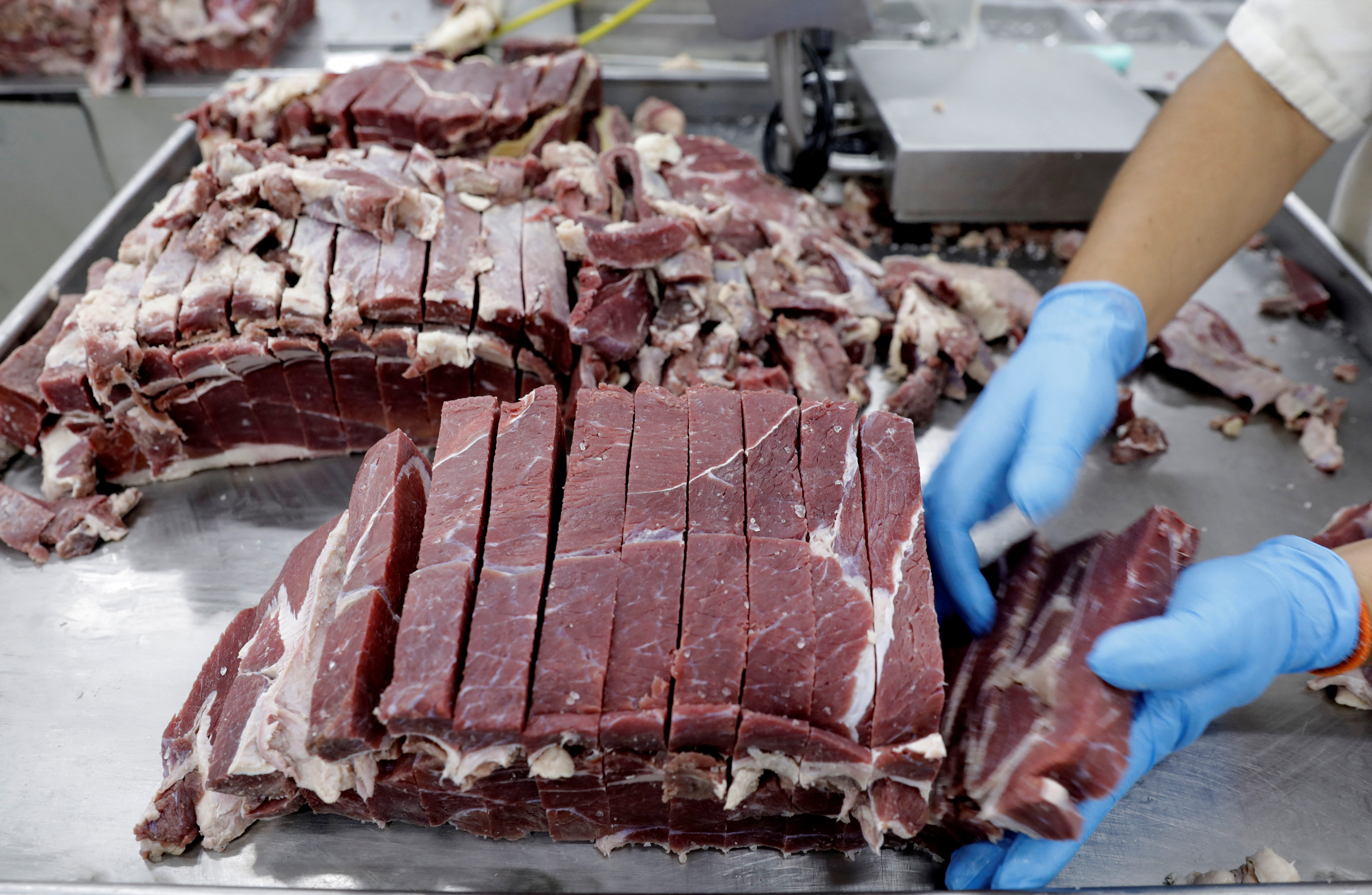 An employee works at the assembly line of jerked beef at a plant of JBS S.A, the world's largest beef producer, in Santana de Parnaiba