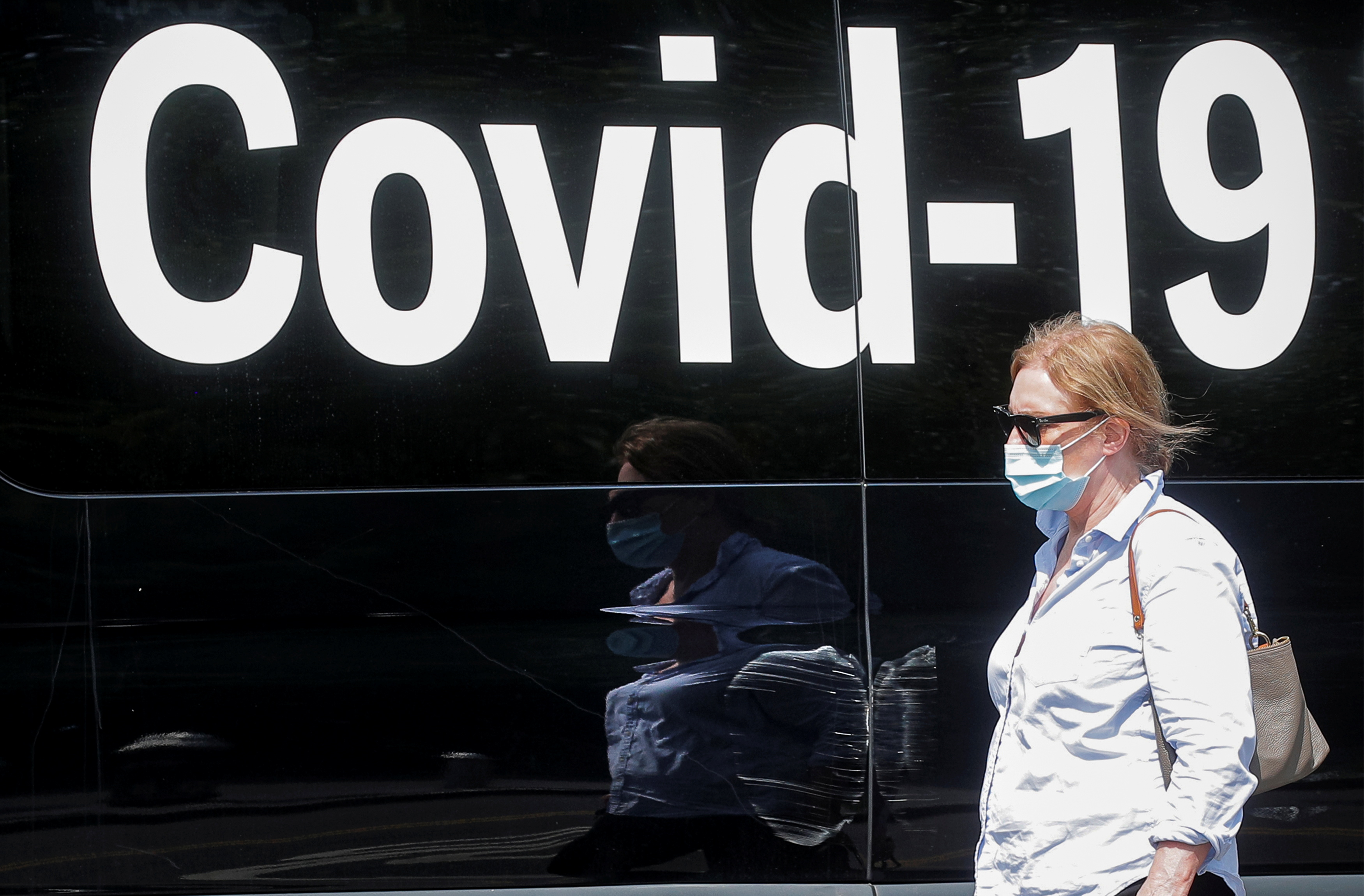 A woman passes by a COVID-19 mobile testing van in New York
