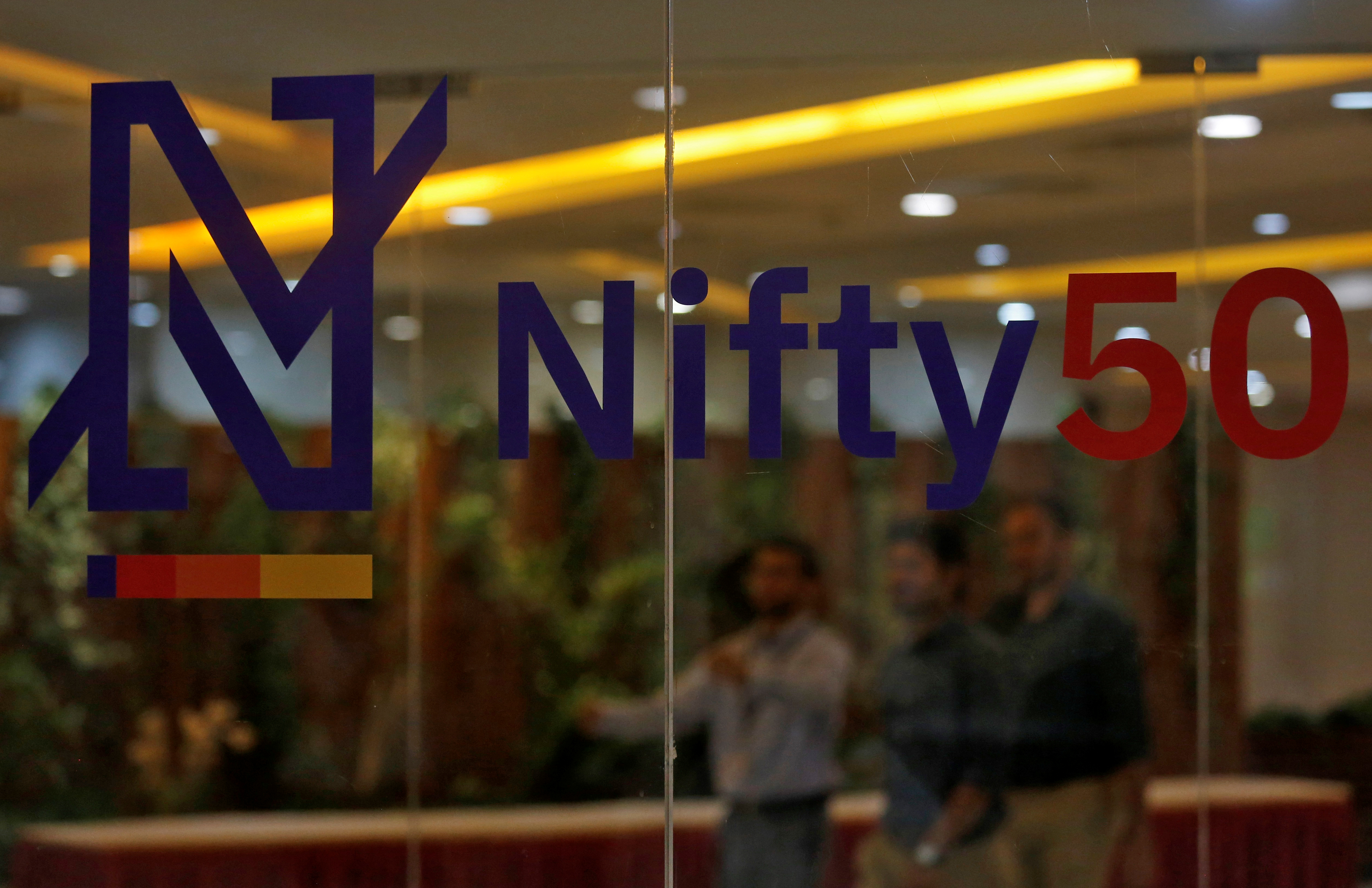 People walk past a new brand identity for Nifty Indices inside the National Stock Exchange building in Mumbai
