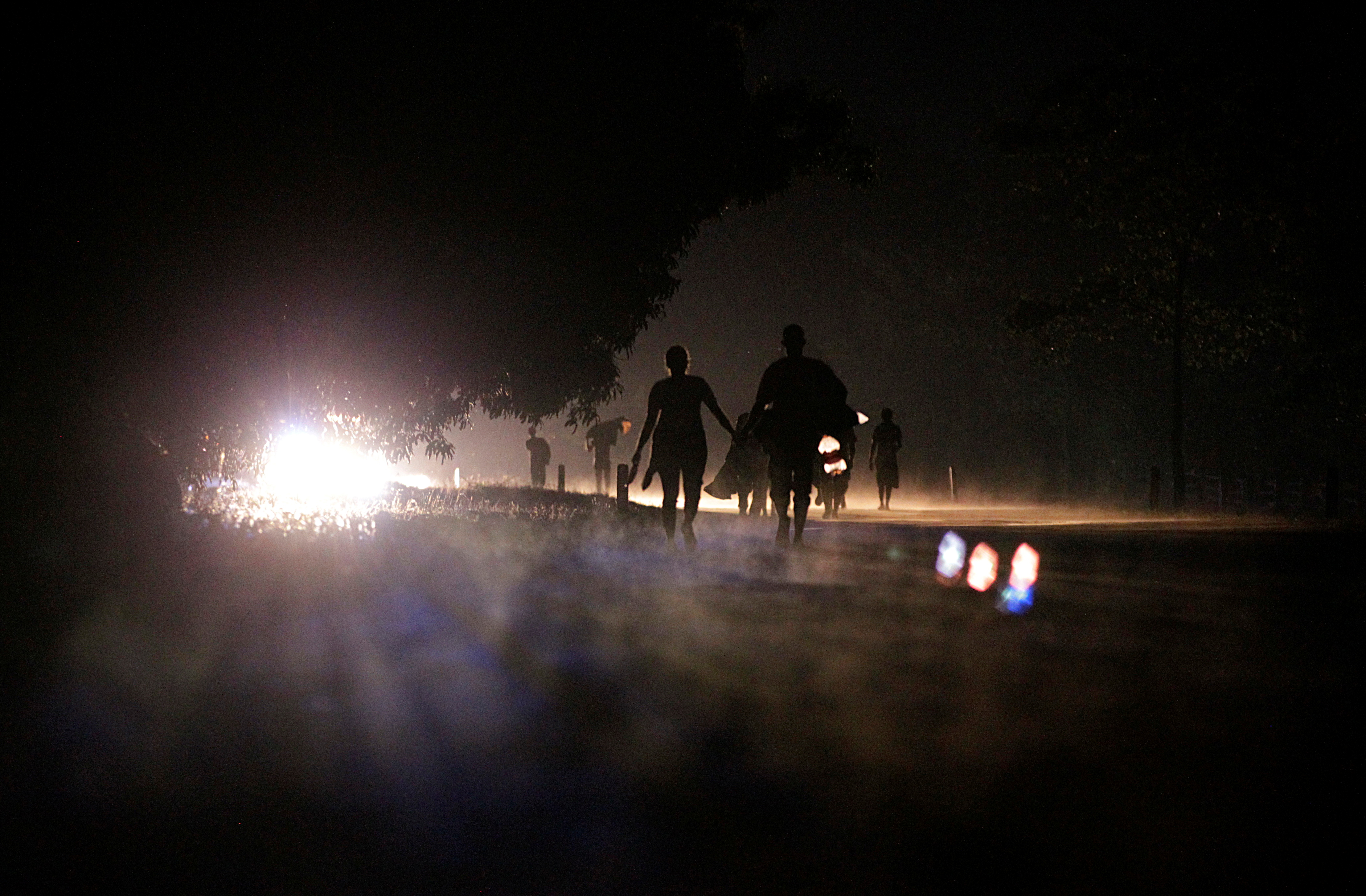 Migrants walk on a road at night as they take part in a caravan heading to Mexico City, in El Fortin, Mexico October 29, 2021. REUTERS/Daniel Becerril