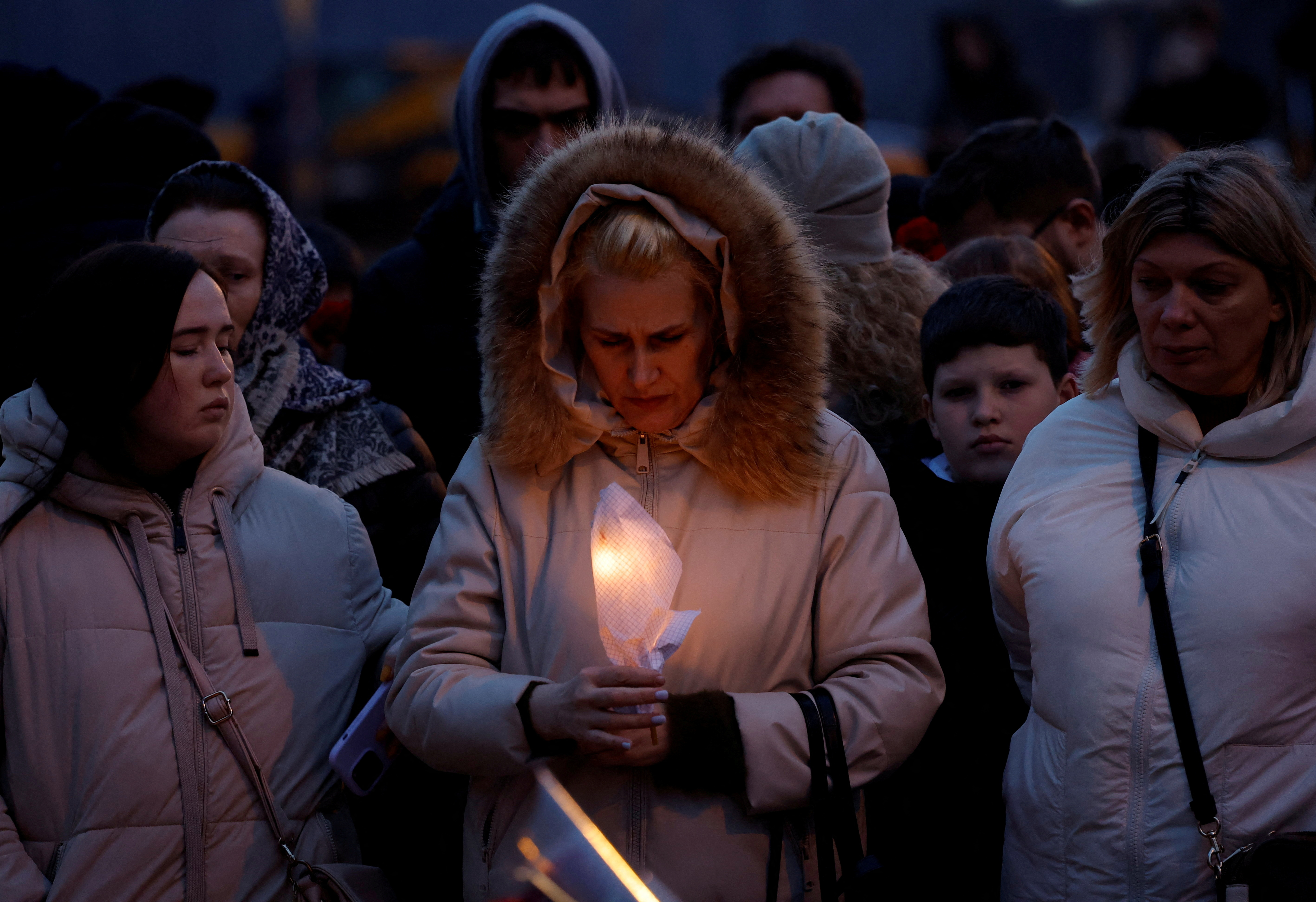 People gather at a makeshift memorial to the victims of a shooting attack at a concert hall outside Moscow