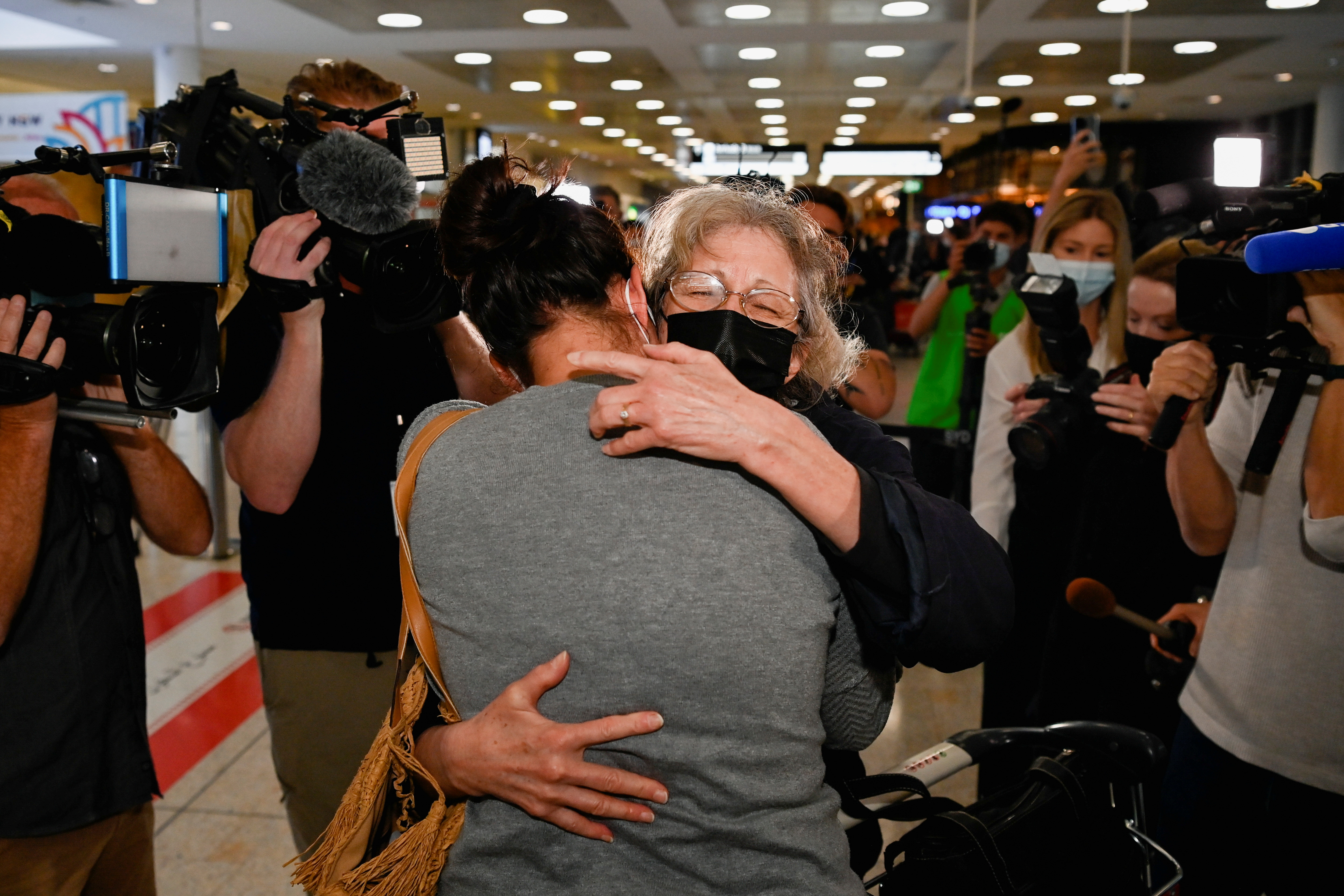 An international traveller is embraced as she arrives at Sydney Airport in the wake of coronavirus disease (COVID-19) border restrictions easing, with fully vaccinated Australians being allowed into Sydney from overseas without quarantine for the first time since March 2020, in Sydney, Australia, November 1, 2021.  REUTERS/Jaimi Joy