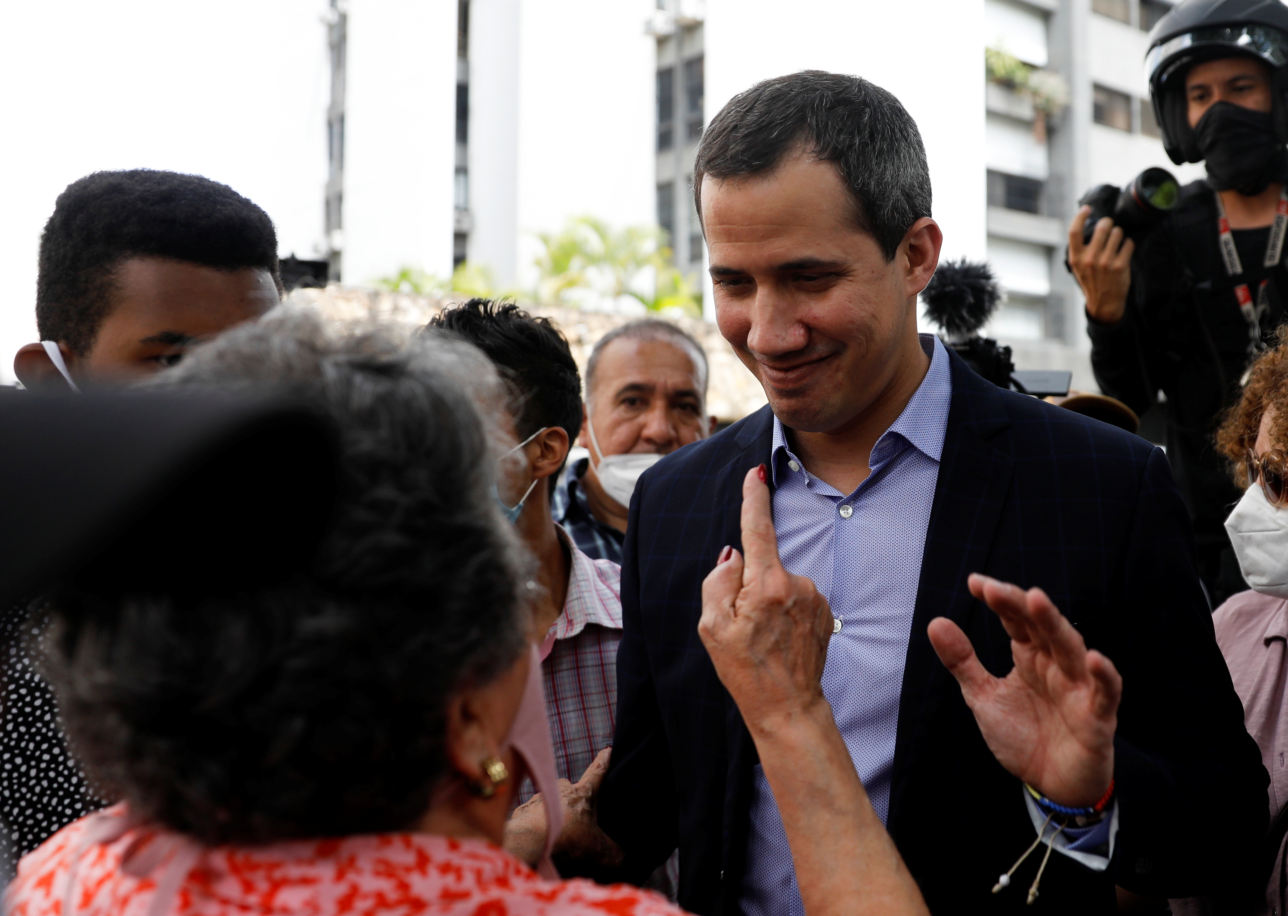 Venezuela's opposition leader Juan Guaido speaks with a woman, in Caracas