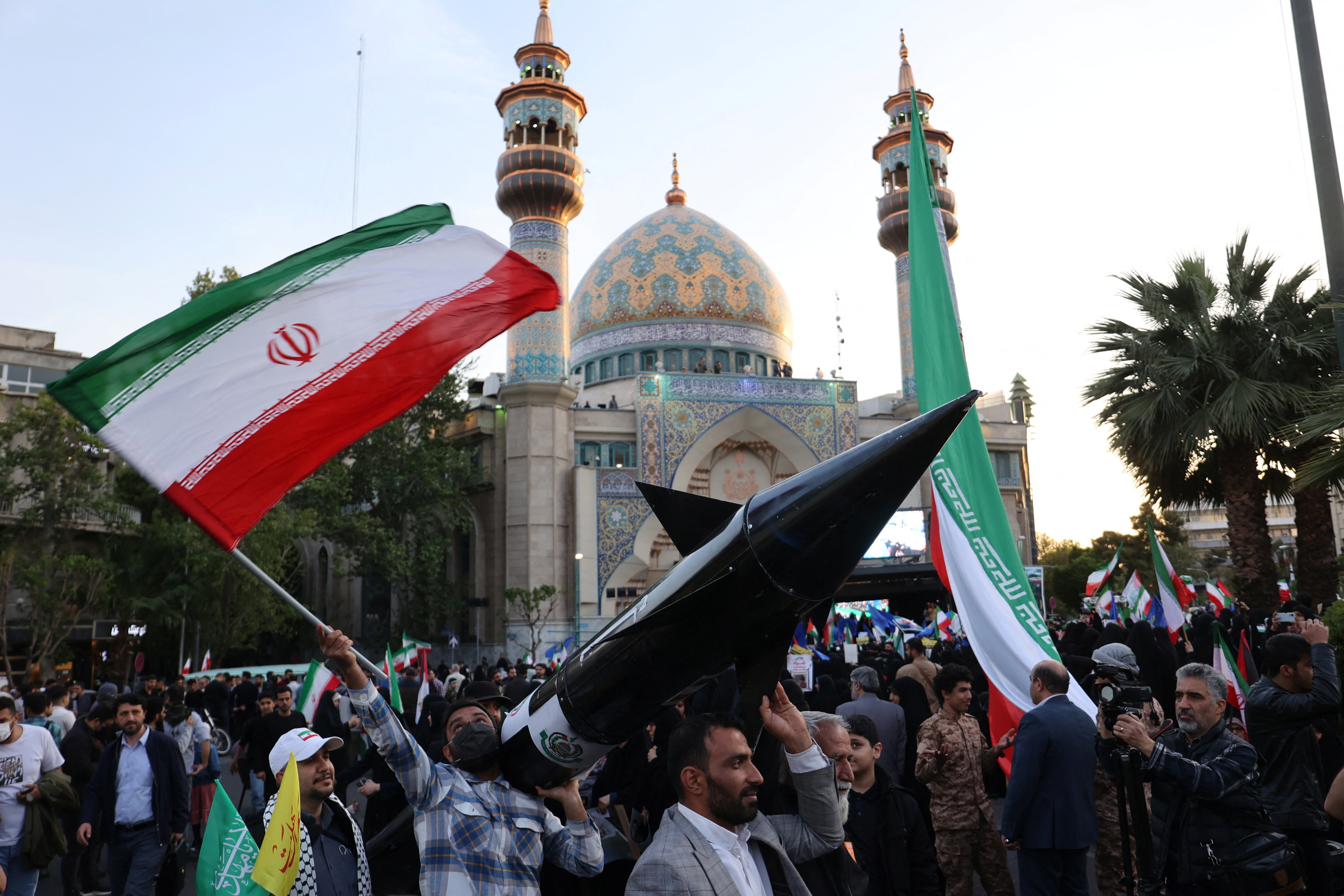 Iranians carry a model of a missile during a celebration following the IRGC attack on Israel, in Tehran