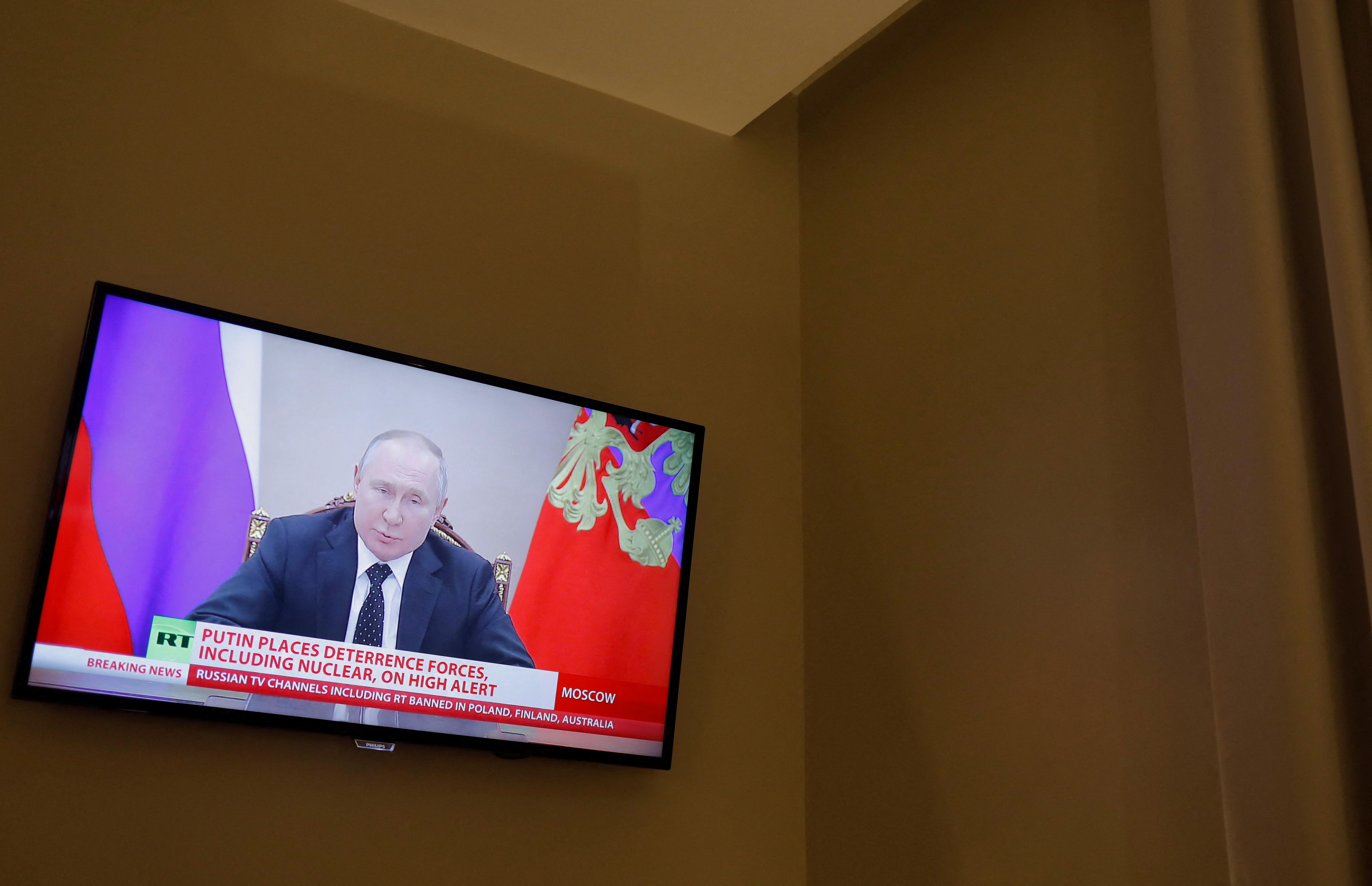 Russian President Vladimir Putin is seen on a TV screen in a hotel during a live news broadcast of the Russia Today (RT) channel TV, in Madrid